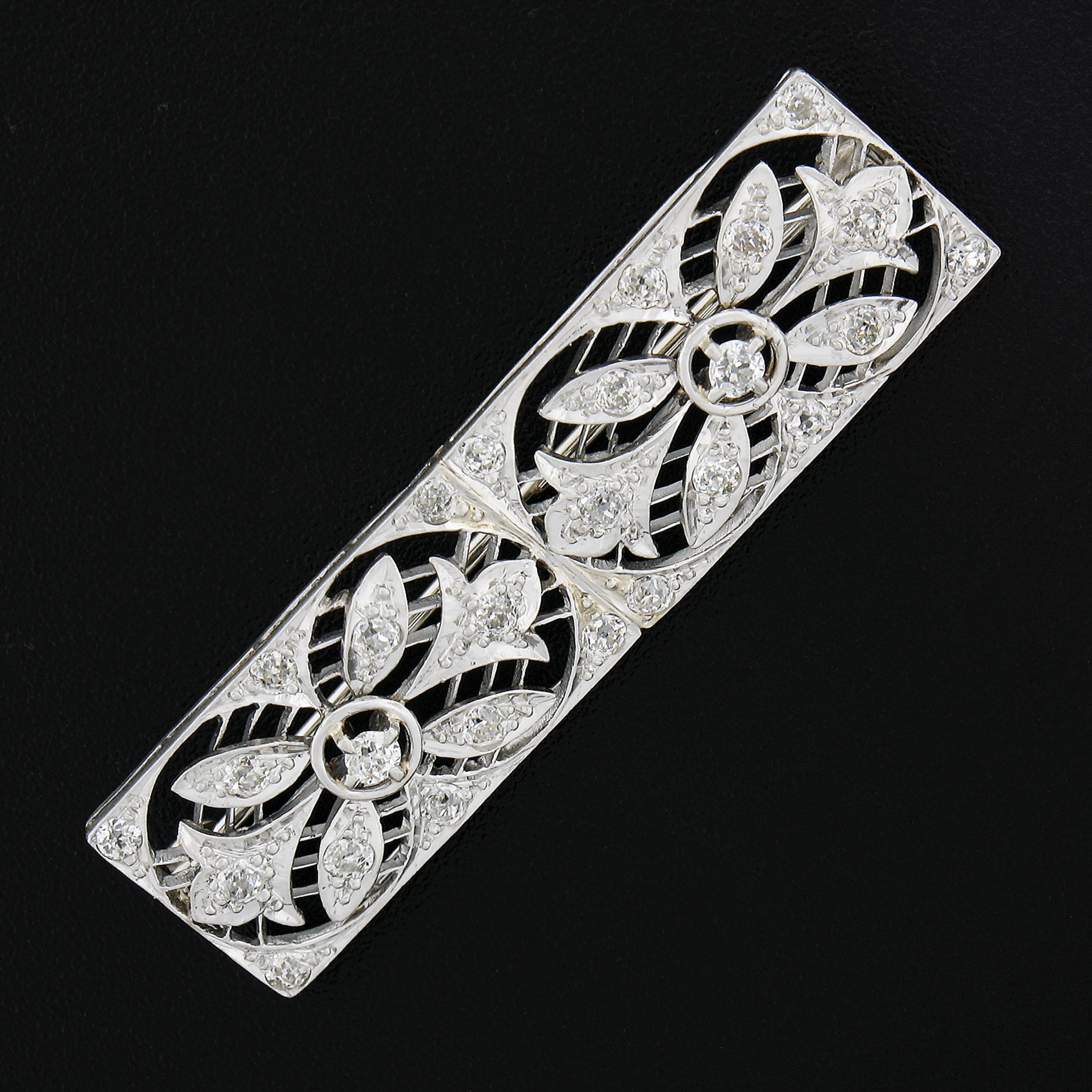Here we have an elegant antique diamond brooch crafted in solid platinum. It features a unique, floral, open, geometric design that is completely drenched in old European and old mine cut diamonds. The fine diamonds on this piece show outstanding