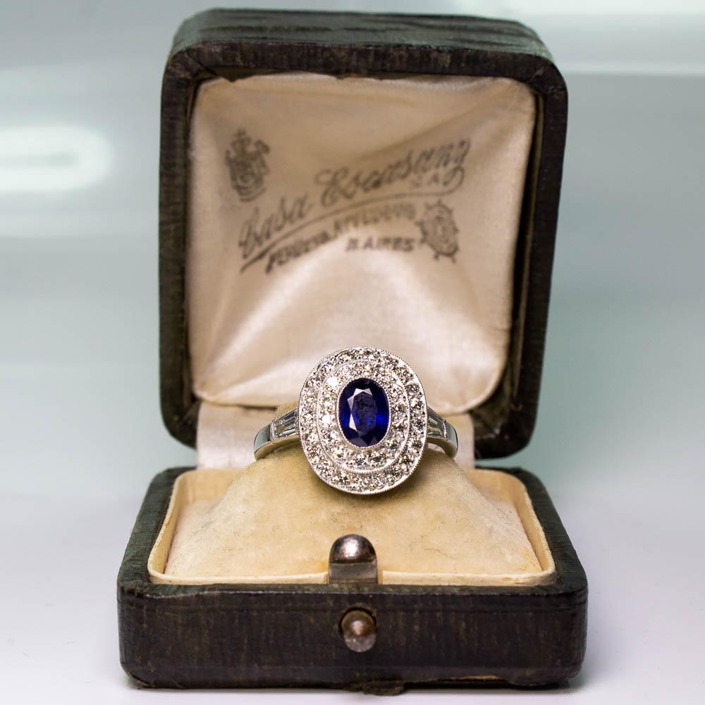 Antique platinum oval sapphire and diamond double halo Art Deco ring. Showcasing one oval fine quality natural sapphire weighing 0.86 carats. Accented with a halo of 37 Old European cut diamonds weighing a total of 0.62 carats, having G–H color