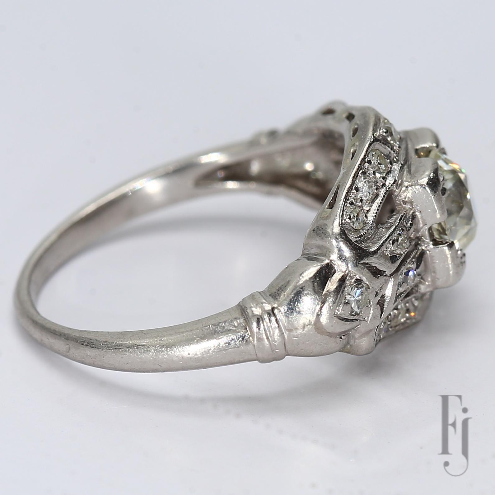 Antiker Platinring mit einem ~1ct 6,5 mm SI1/J Diamanten im zentralen europäischen Altschliff und zwanzig runden 1,75 mm 0,02ct SI2/H Diamanten als Akzent

Ring Größe 5.75
Gesamtgewicht - 3,74 g
A2