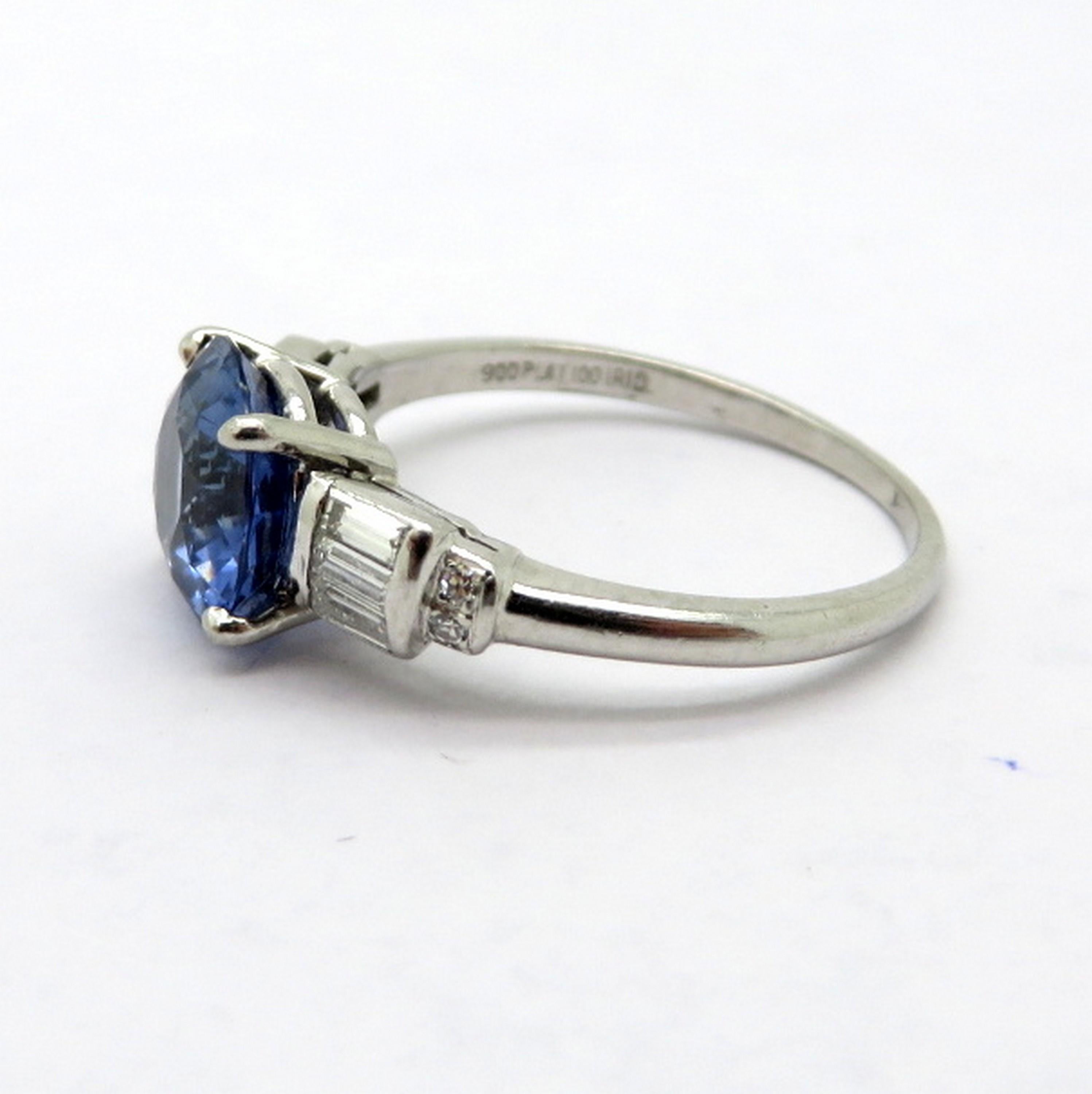 Antique platinum round sapphire and baguette diamond fashion statement ring. Showcasing one round brilliant cut fine quality sapphire, four prong basket set, weighing approximately 2.25 carats. Accented with six tapered baguette shaped diamonds and