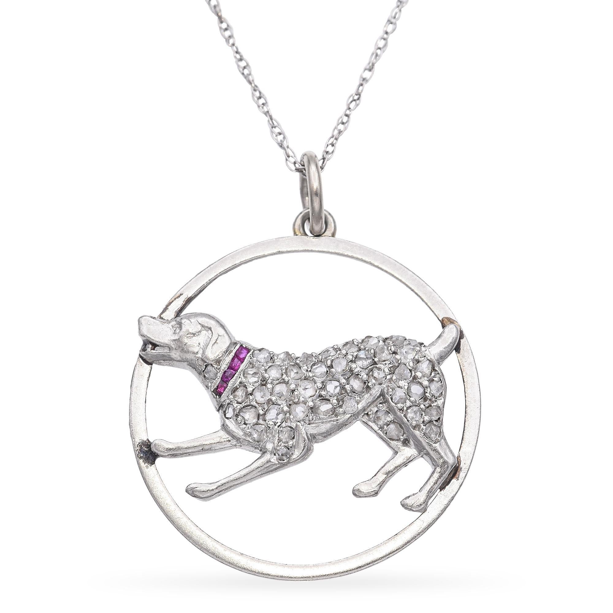 Un encantador collar colgante con un juguetón motivo de perro. Elaborada en platino, esta pieza muestra una detallada figura de perro adornada con diamantes talla rosa. El perro lleva un collar engastado con un vibrante rubí, que añade un toque de