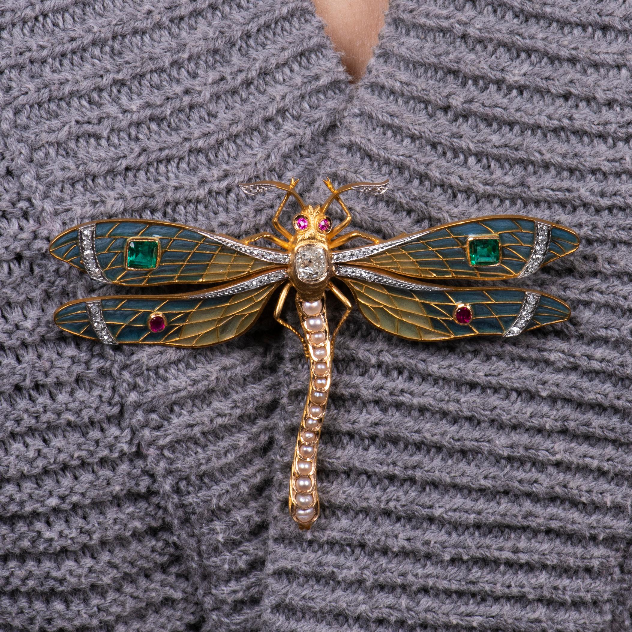 Immaculate plique a jour dragonfly brooch in 22K yellow gold with one 0.90 carat fine cushion brilliant diamond, 2 fine emerald cut natural emeralds of approx 0.70ct total, measuring approximately 4.05mm each, .25 carats in four natural rubies and a
