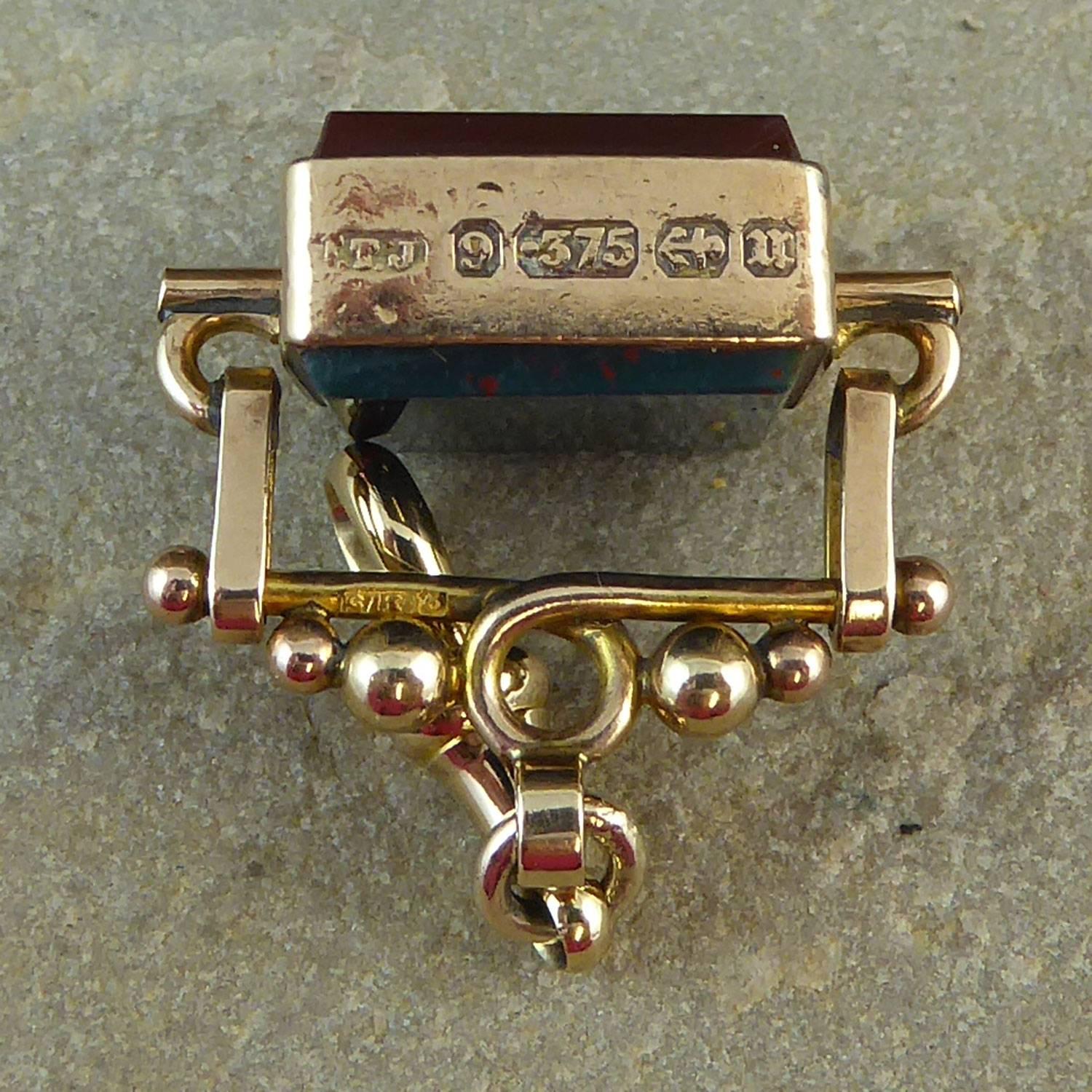 Dating from 1919 this antique fob features a cornelian to one side and a bloodstone to the other, both cut in a square with chamfered edges.  The fob swivels in a yellow gold frame which on one edge shows the hallmark from the Birmingham Assay