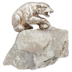 Ancien cube d'ours polaire en métal argenté sur roche de quartz