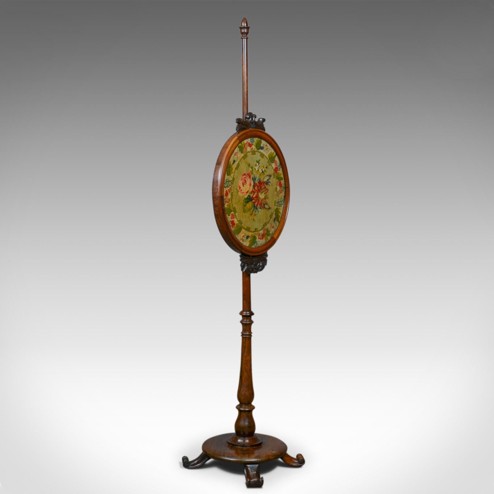 This is an antique pole screen, an English, Regency fire screen with needlepoint tapestry panel dating to the early 19th century, circa 1815.

Raised on a fine rosewood stand with good color and grain interest
Adjustable, circular needlepoint