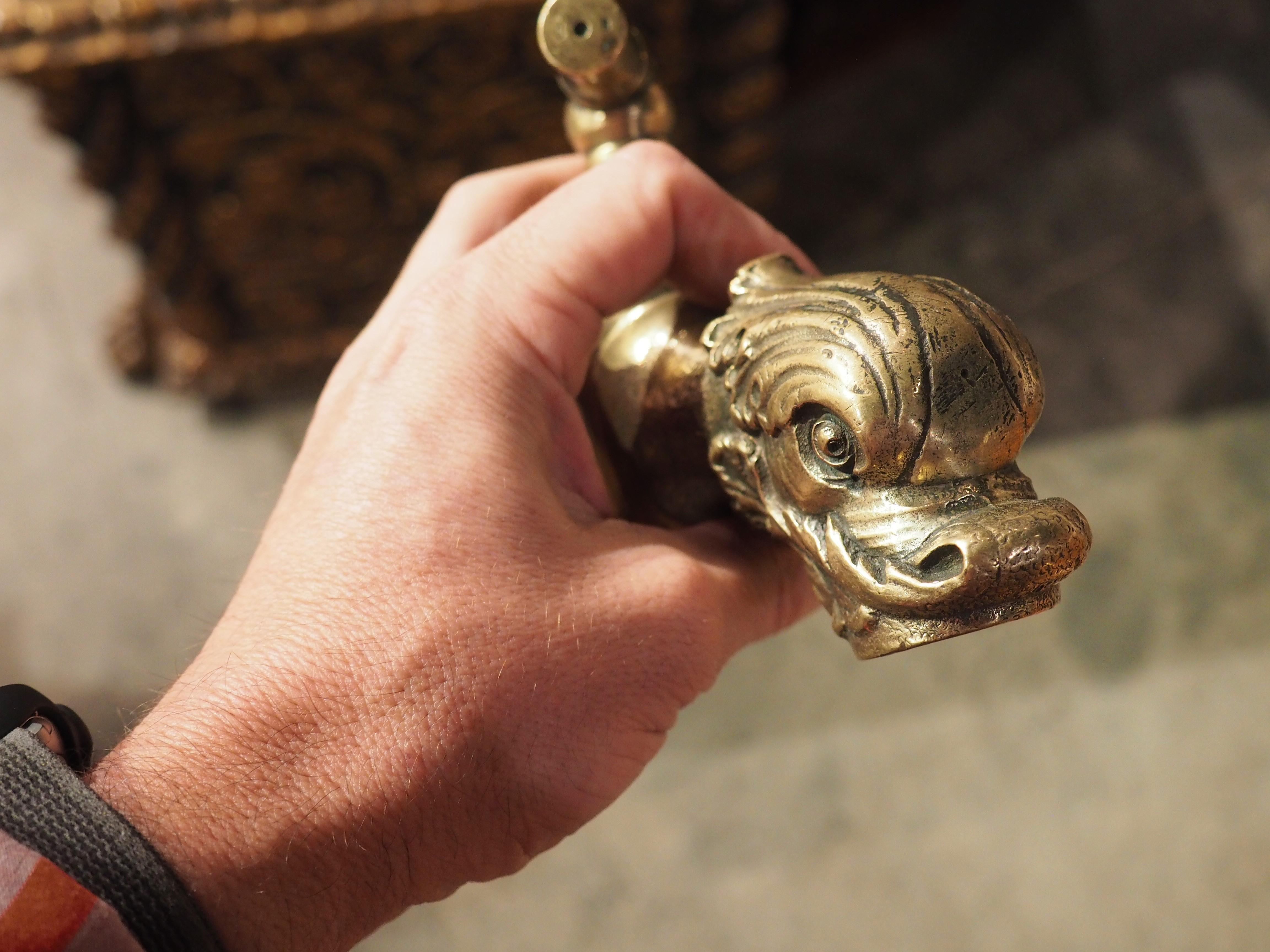 An interesting polished bronze spout that was cast in France during the mid-1800s. The spout is in the form of a stylized dolphin head comprised of a foliate cup, with the mouth functioning as the exit point. There is a linear handle (stamped with