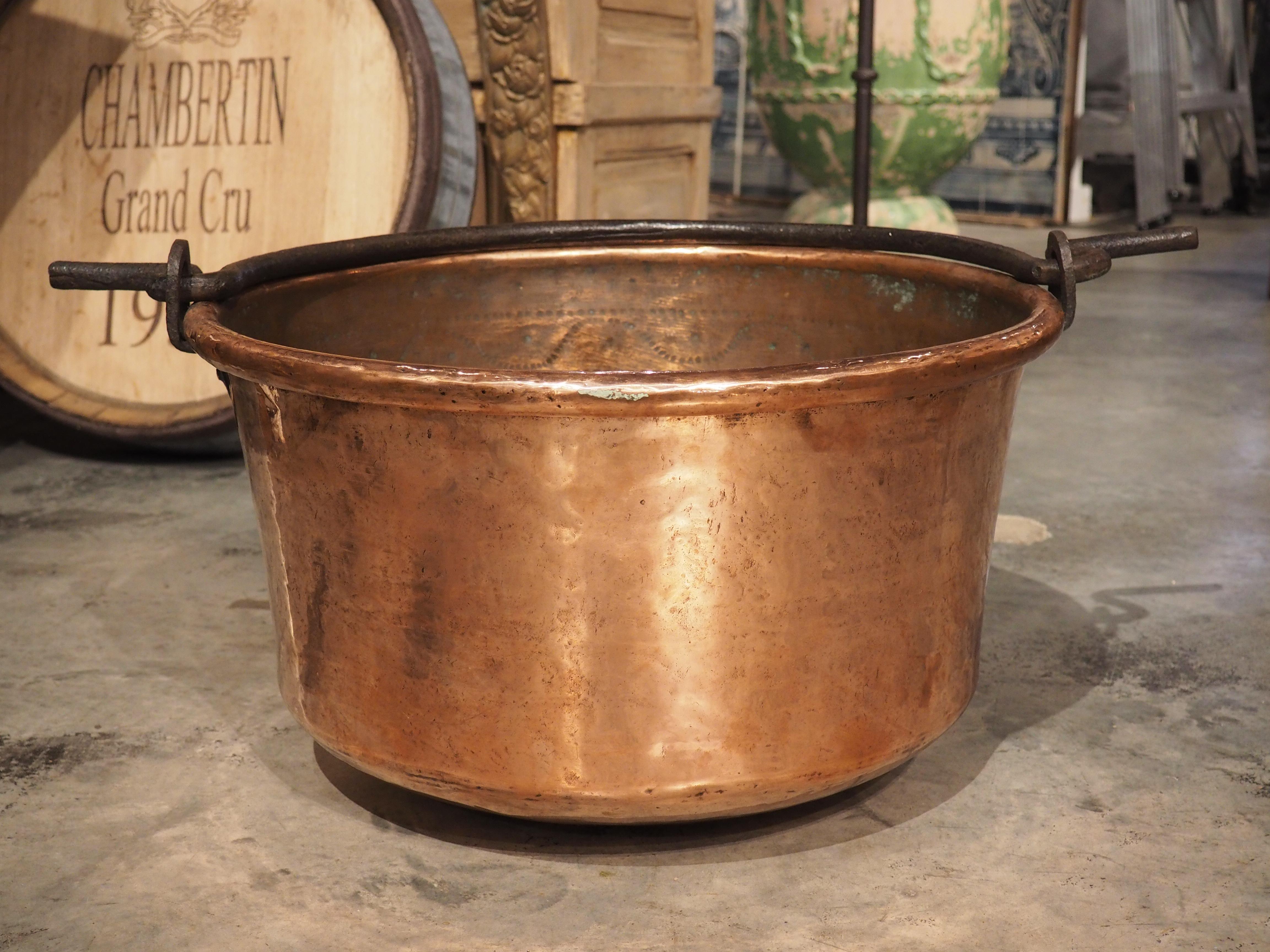 Antique copper cookware, such as this polished chaudron with wrought iron handle are highly sought-after decorative pieces due to their unique color and (typically) bright patina. handcrafted in France, circa 1850, our chaudron has a shaped wrought