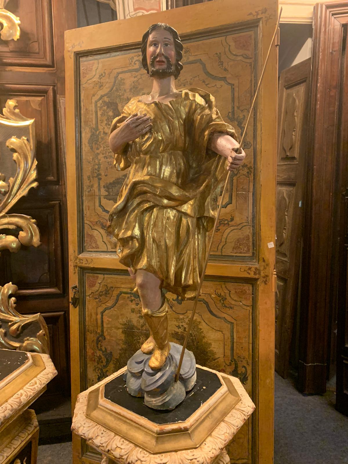 Ancient wooden statue, hand-carved depicting a devotee, with hand-made polychrome and gilded lacquering, built in the late 1700s for a church in Italy.

Size cm W 45 x H 97 x T 27.