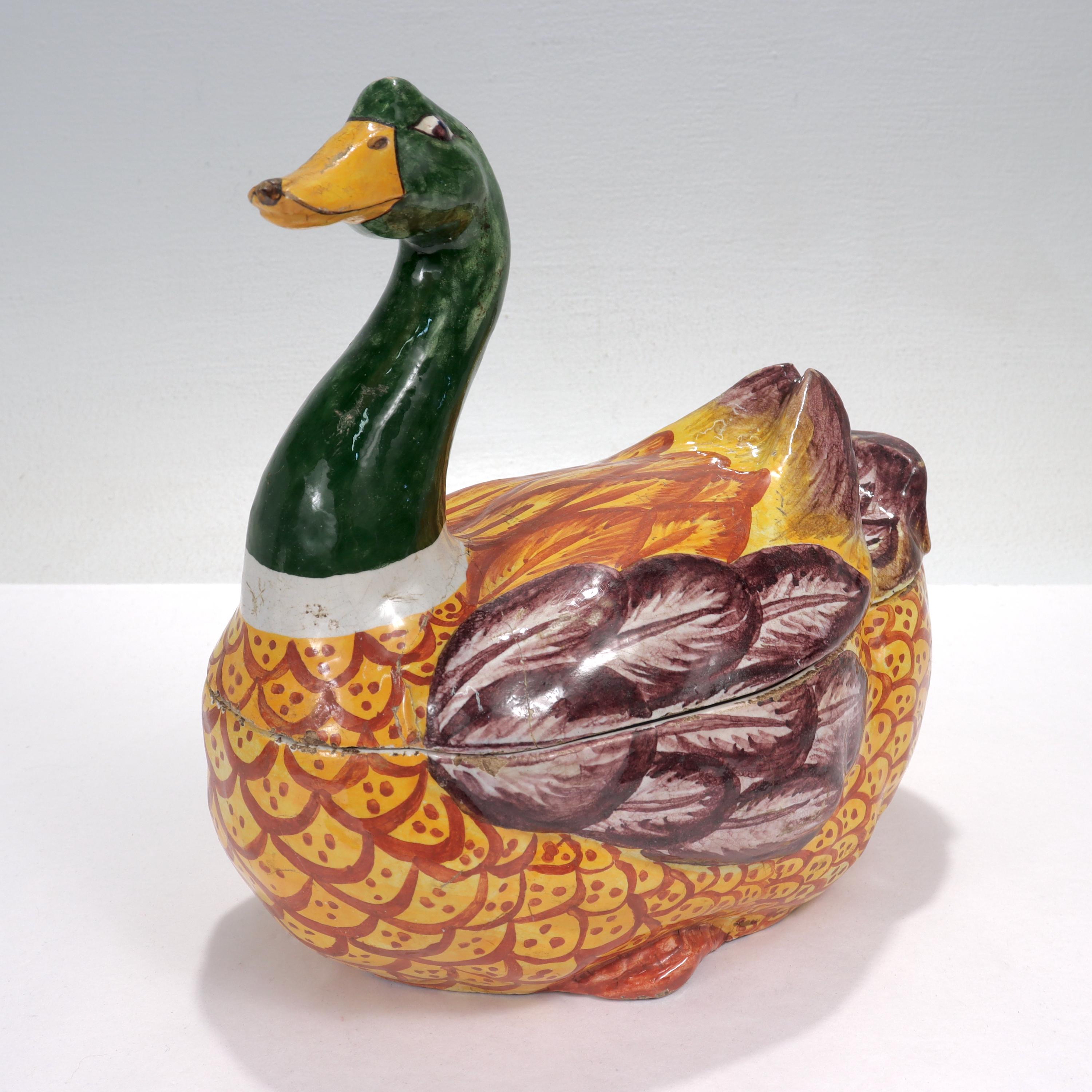 A fine antique Delft figural tureen or box.

In the form of a polychrome female duck with rich red, yellow, and purple plumage. 

The top half of the duck is a removable lid.

Marked with a blue 'KF' maker's mark to the base.

Simply a great piece