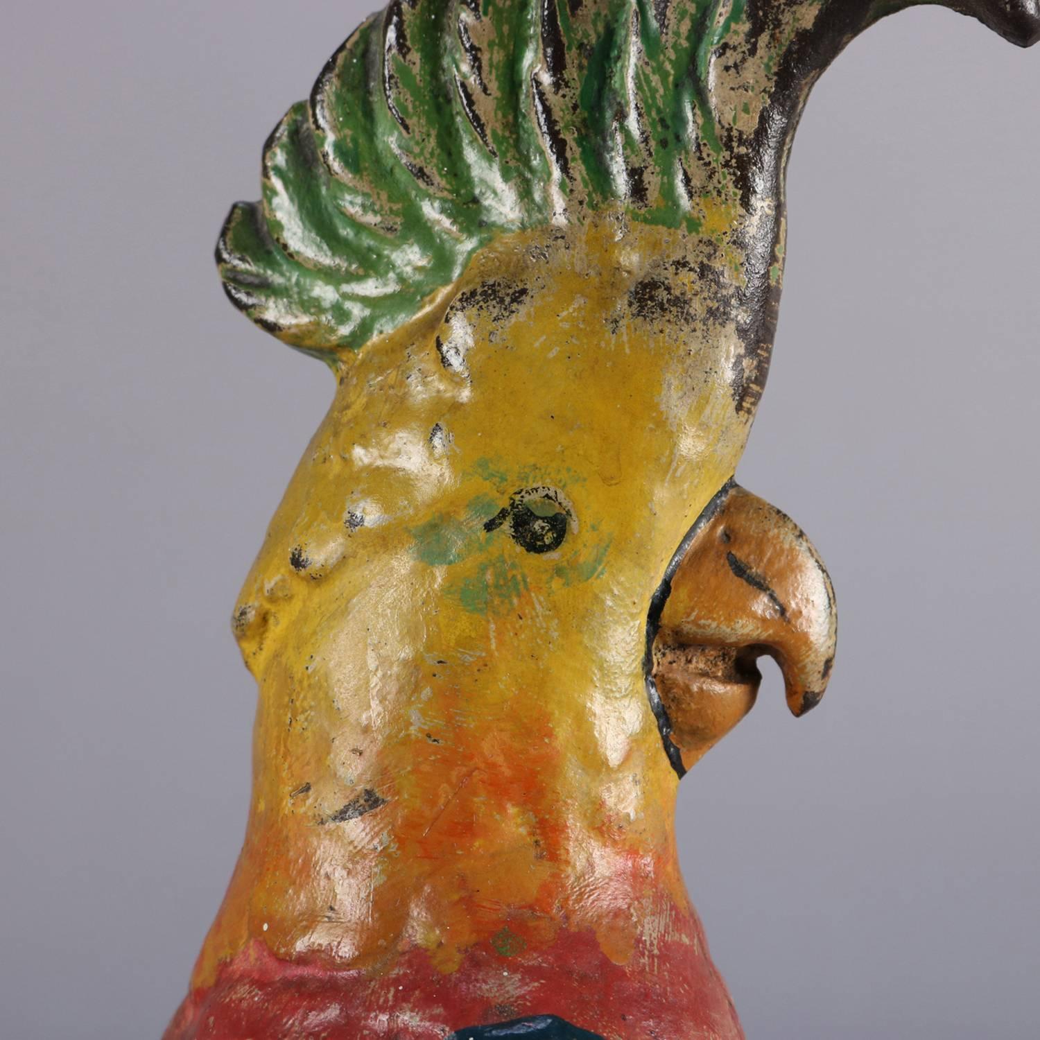 Antique figural cast iron doorstop features hand-painted polychromed bird sculpture of a parrot with flared crest and seated on a tree branch, reminiscent of Polly Parrot, circa 1890.

Measures: 14