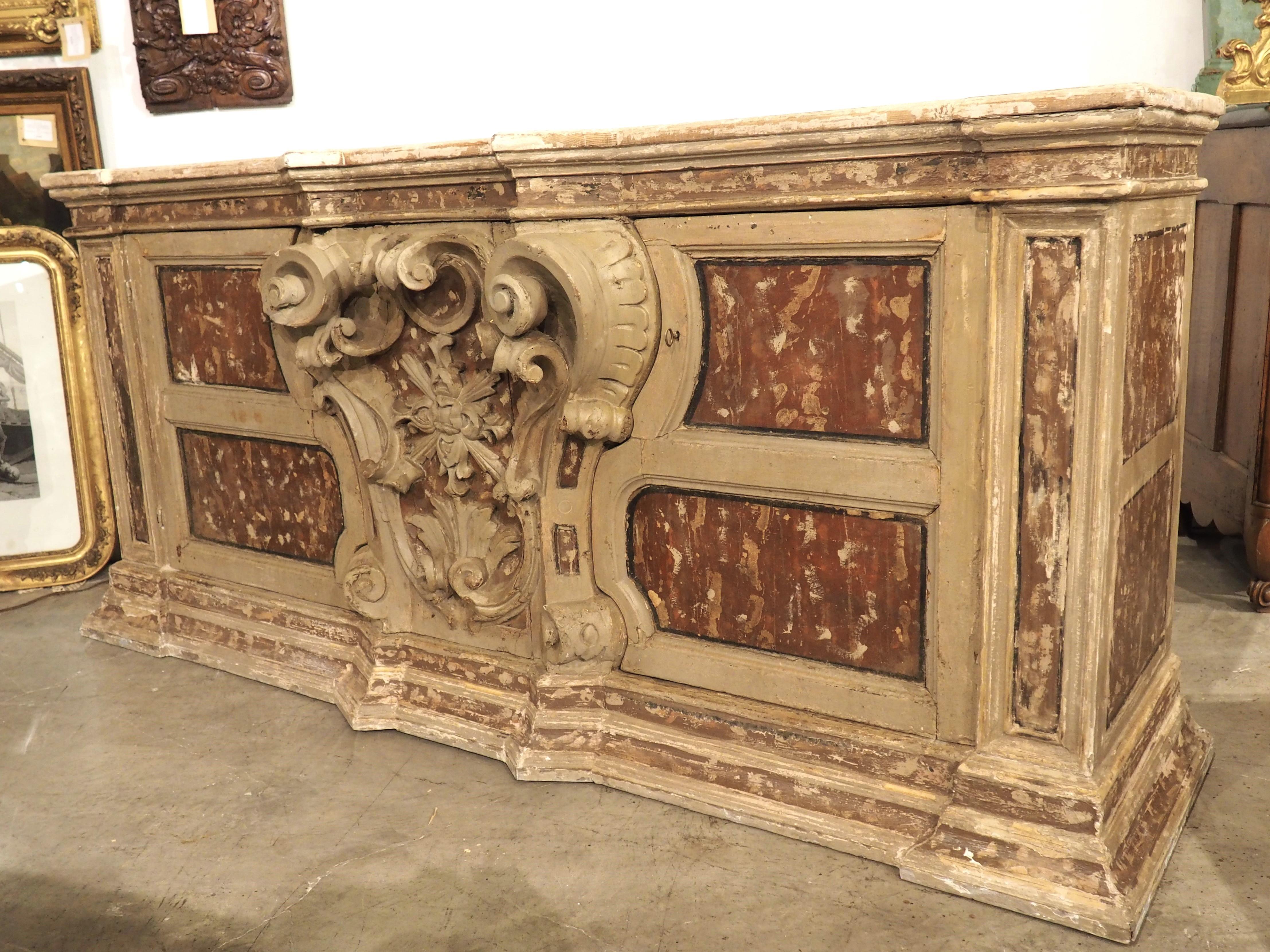 Dating to the 1700s, the central cartouche of this credenza buffet was originally from an altar, in Naples, Italy. The cartouche is a fantastic relief carving of a highly scrolled console with a foliate medallion encompassed by volutes, scrolls, and