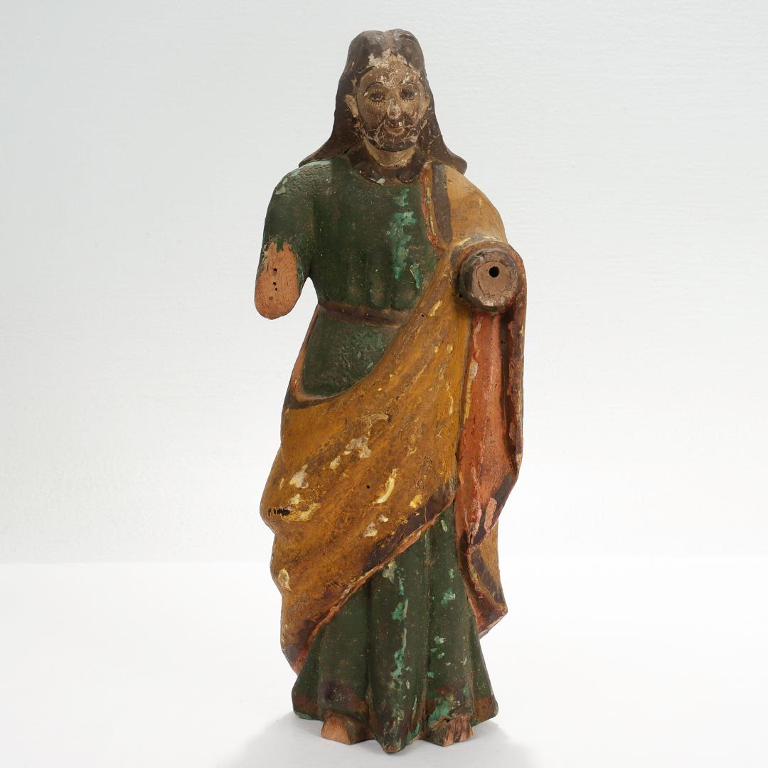 A fine antique Santos figurine.

In polychrome painted decoration over carved wood and some areas of gesso.

Likely Latin-American in origin.

We're unsure which saint is depicted with this figure.

Simply a wonderful piece of religious