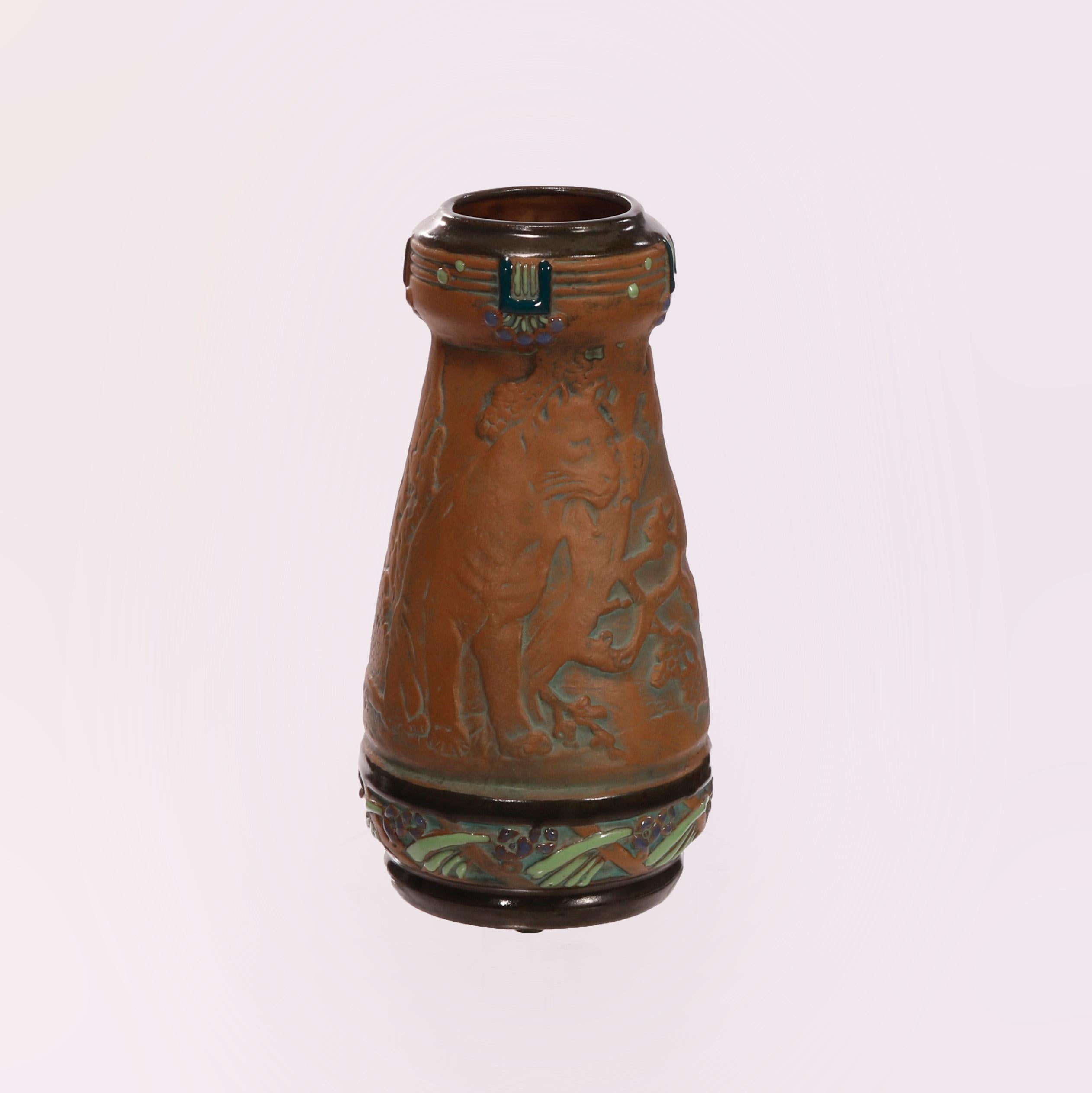 An antique Arts & Crafts vase offers Amphora pottery construction with a wild cat in countryside setting carved in relief, polychromed band with enameled stylized foliate elements, marked on base as photographed, c1910

Measures - 9.25'' H x 4.75''