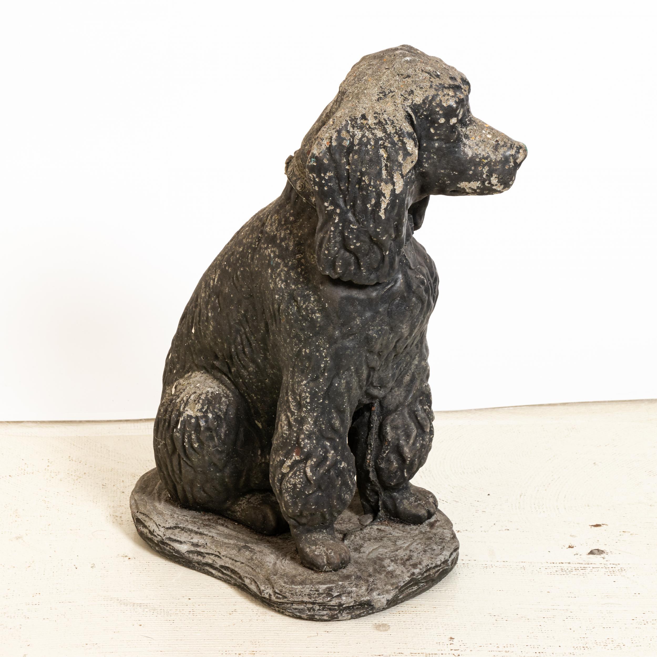 Unique cast stone garden statue in the shape of a seated poodle dog. Made in England in the early 20th century, this charming statue a playful element to add to the landscape. Nice texture at the curly coat of the dog. Good condition, weathered with