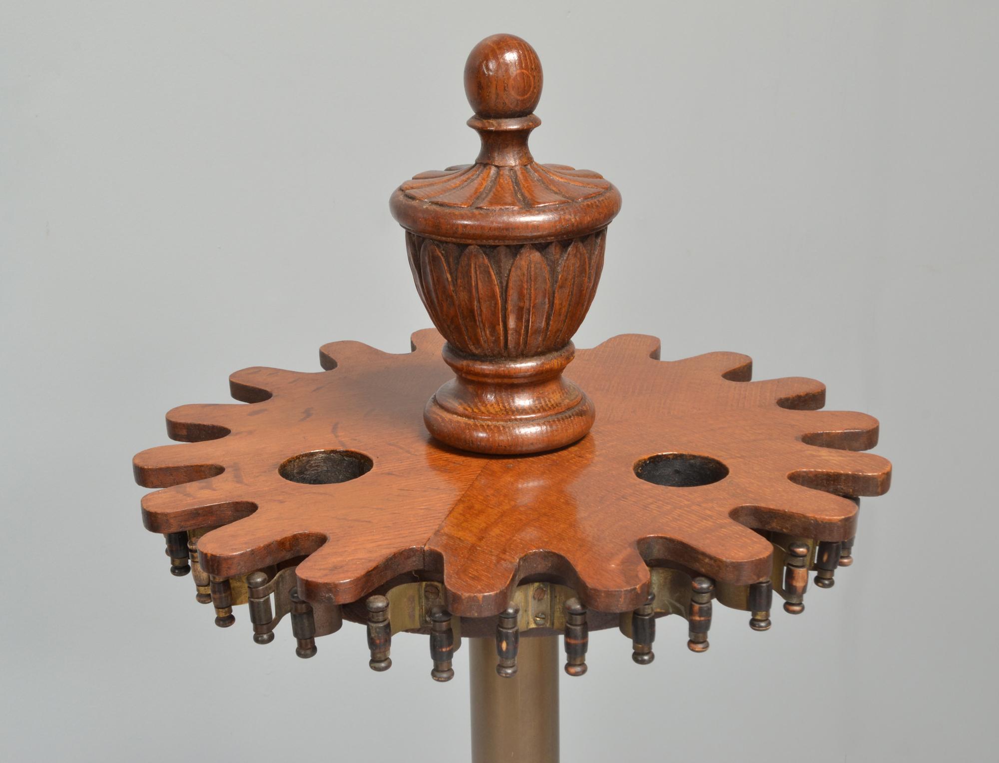 A revolving pool cue carousel or stick stand or rack by John Thurston of London, circa 1880.

A decorative carved finial above a flat shaped top with ebony brass sprung cue clips, connected to the gadrooned turntable base with a tubular brass