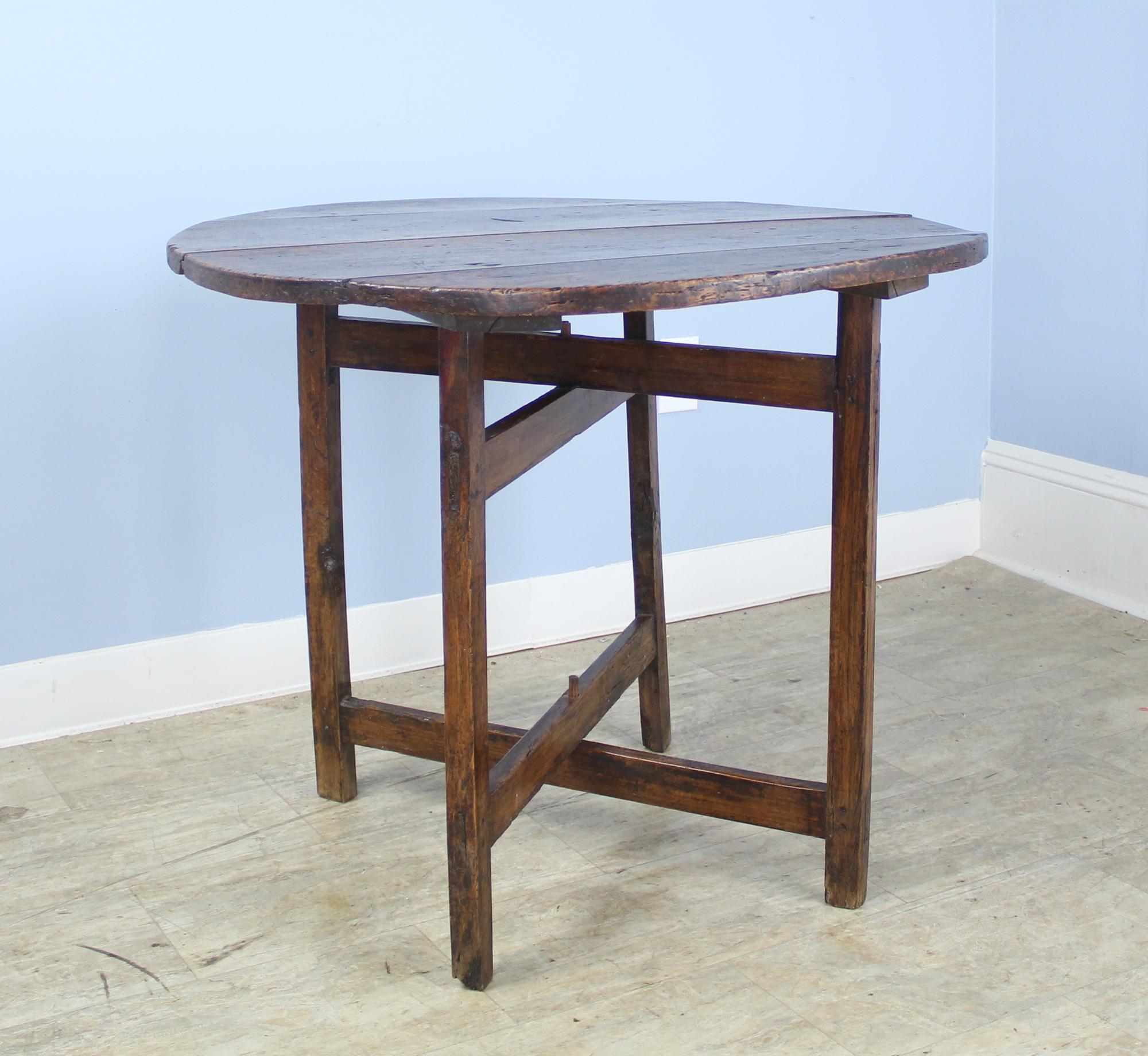 A mid-19th century French X-based side, lamp or occasional table in rich poplar. This was originally a small picnic or wine table that folded for easy transport. We have secured the top to the base permanently for stability. There is some waviness