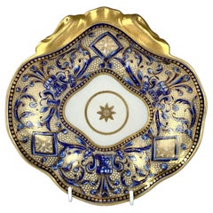 Plato antiguo de porcelana azul y dorada en forma de concha Inglaterra Circa 1810