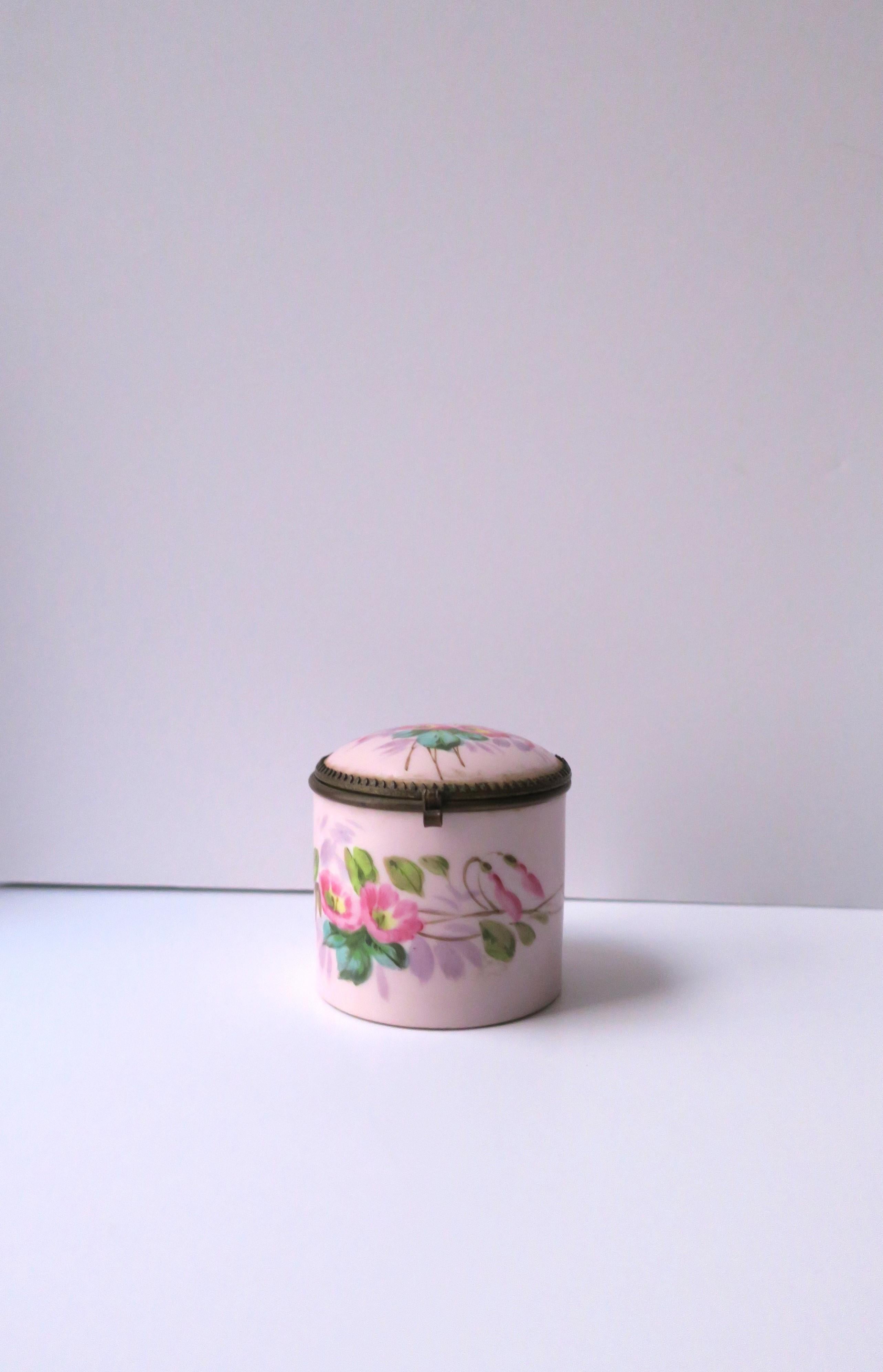 An antique porcelain box with floral chintz design, circa early-20th century, Europe. This porcelain box has a hinged lid with an all-white interior. Exterior is surrounded by hand-painted flowers and leaves. A pretty box to hold jewelry