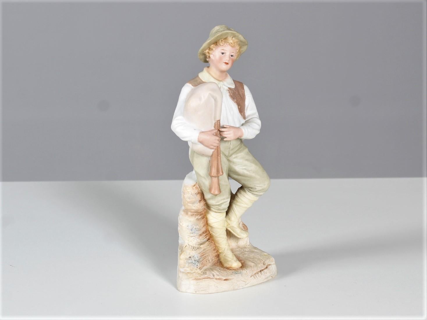 Antique porcelain sculpture by Heubach brothers from Lichte, in Thüringen Germany.
Depicted is a boy with a bagpipe sitting on a rock.
The stamp of the porcelain manufactory 