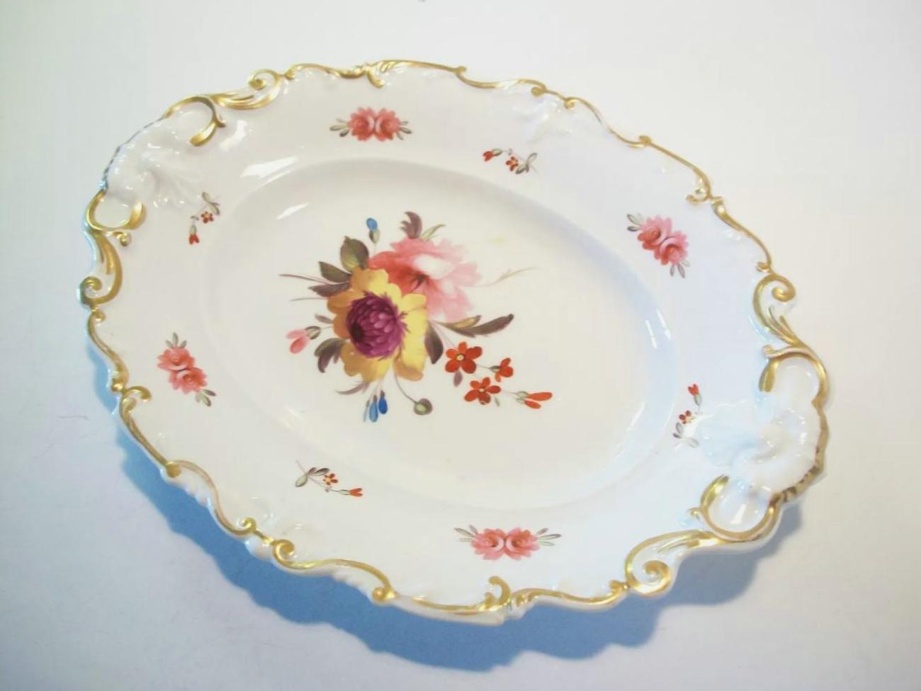 Ancien plat de service ou assiette de cabinet en porcelaine anglaise décorative avec un motif floral peint à la main - bord doré décoré de coquillages et de rinceaux en relief - numéro de motif '768' peint en violet - Royaume-Uni - Fin du 19e