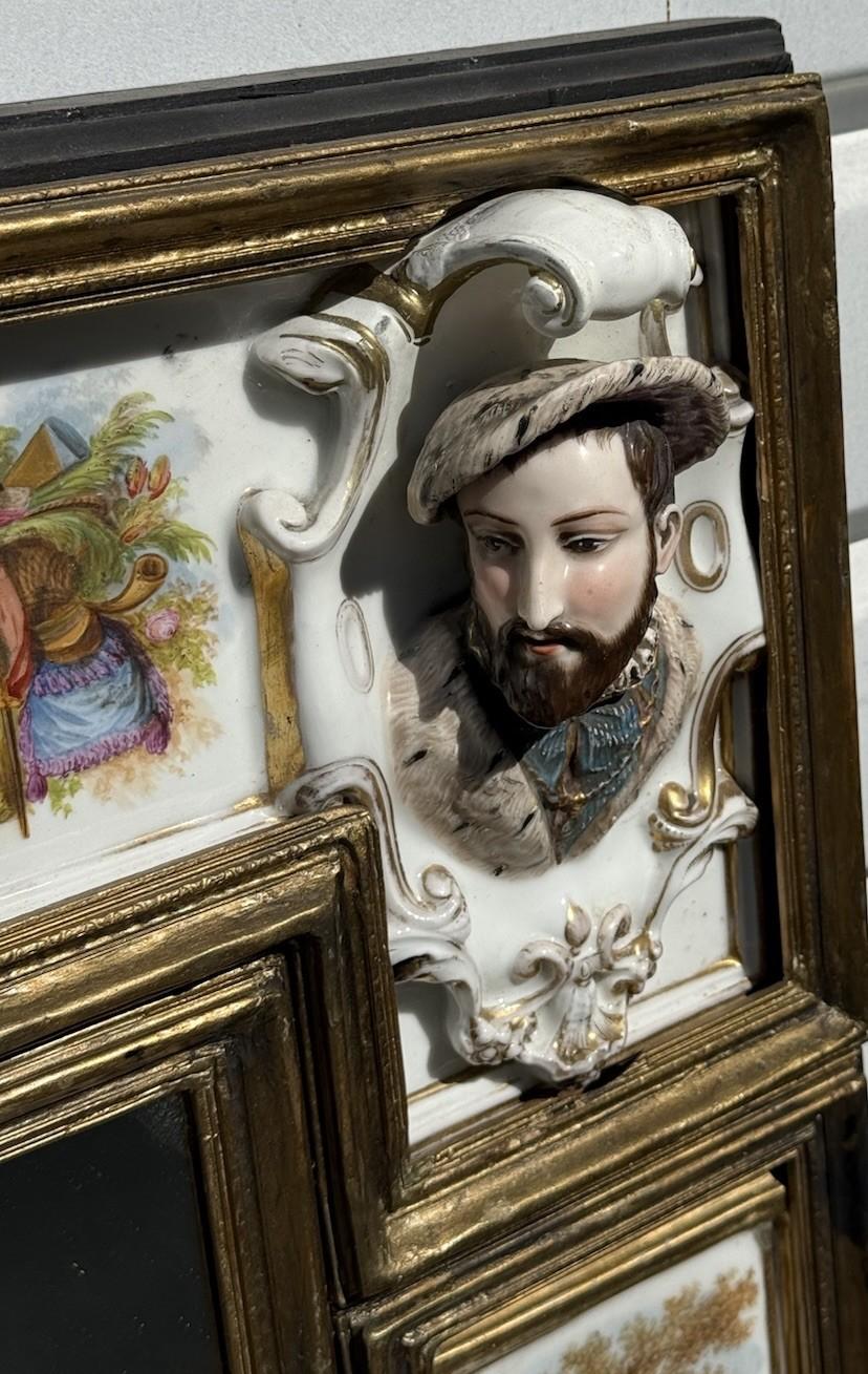 Un remarquable miroir ancien richement orné de plaques de porcelaine peintes à la main, de bustes tridimensionnels et de panneaux de malachite dans un cadre en bois doré. Cette pièce impressionnante incarne l'opulence et le savoir-faire des arts