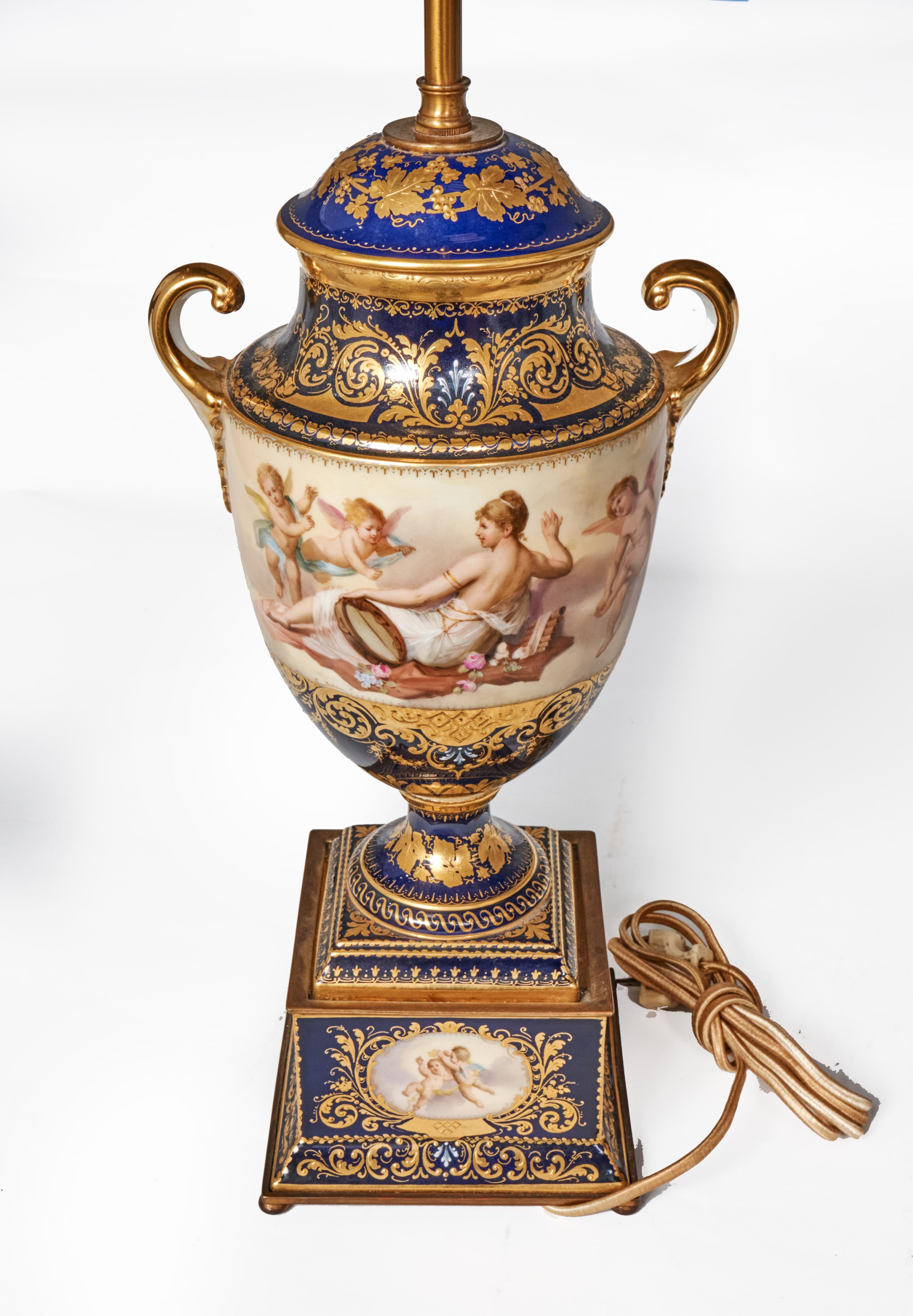 Lovely antique hand painted Royal Vienna table lamp with cobalt blue glaze decorated with gold. Hand painted scenes of frolicking cherubs and a semi-nude young woman. Artist signed as shown in pictures and also signed on the bottom.
Lamps are urn