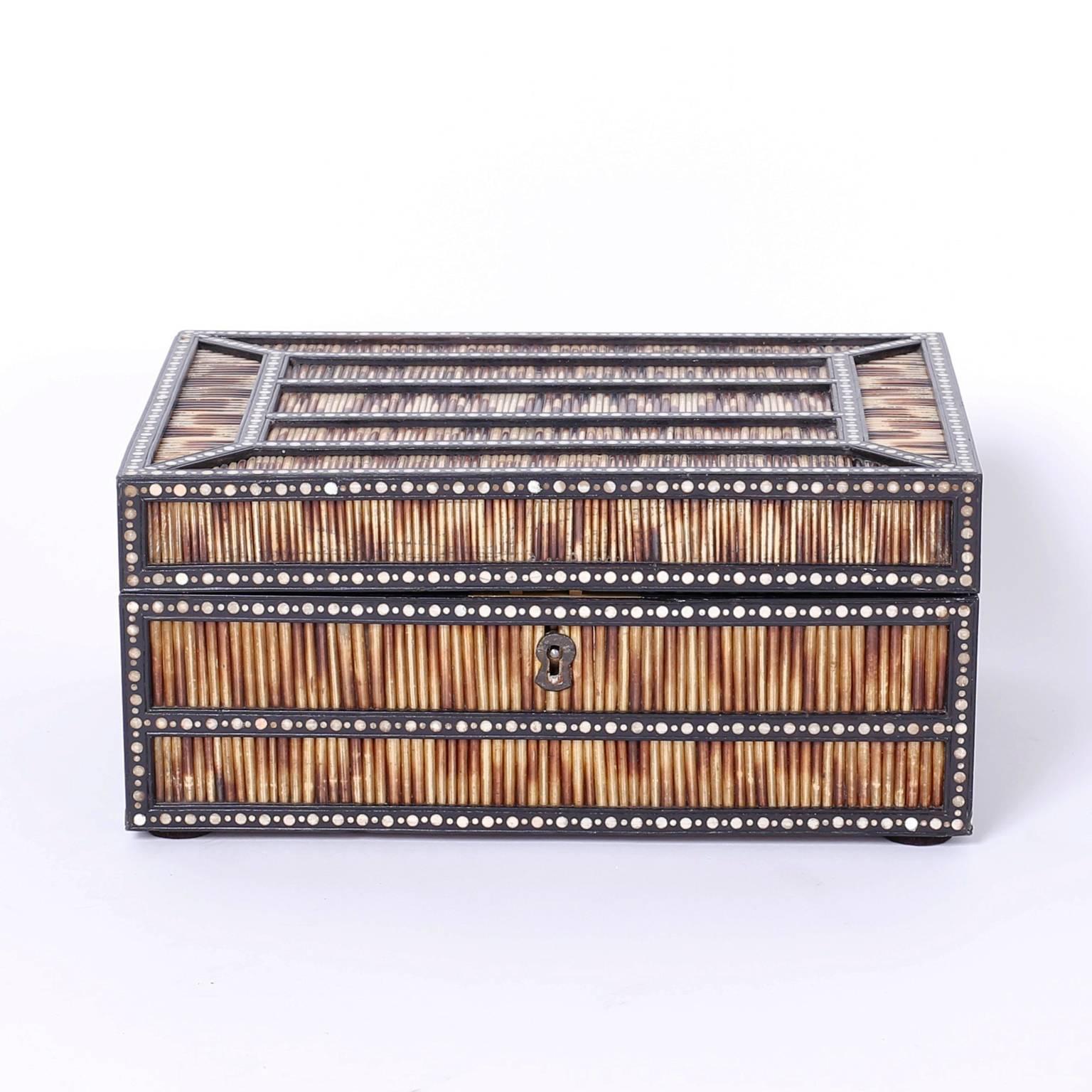 Intriguing rare antique box crafted in tropical hardwoods, porcupine quills, and bone dot inlays. The interior features a panel depicting two elephants intertwined with symbolic floral designs and rare and unusual five quill lidded compartments, a
