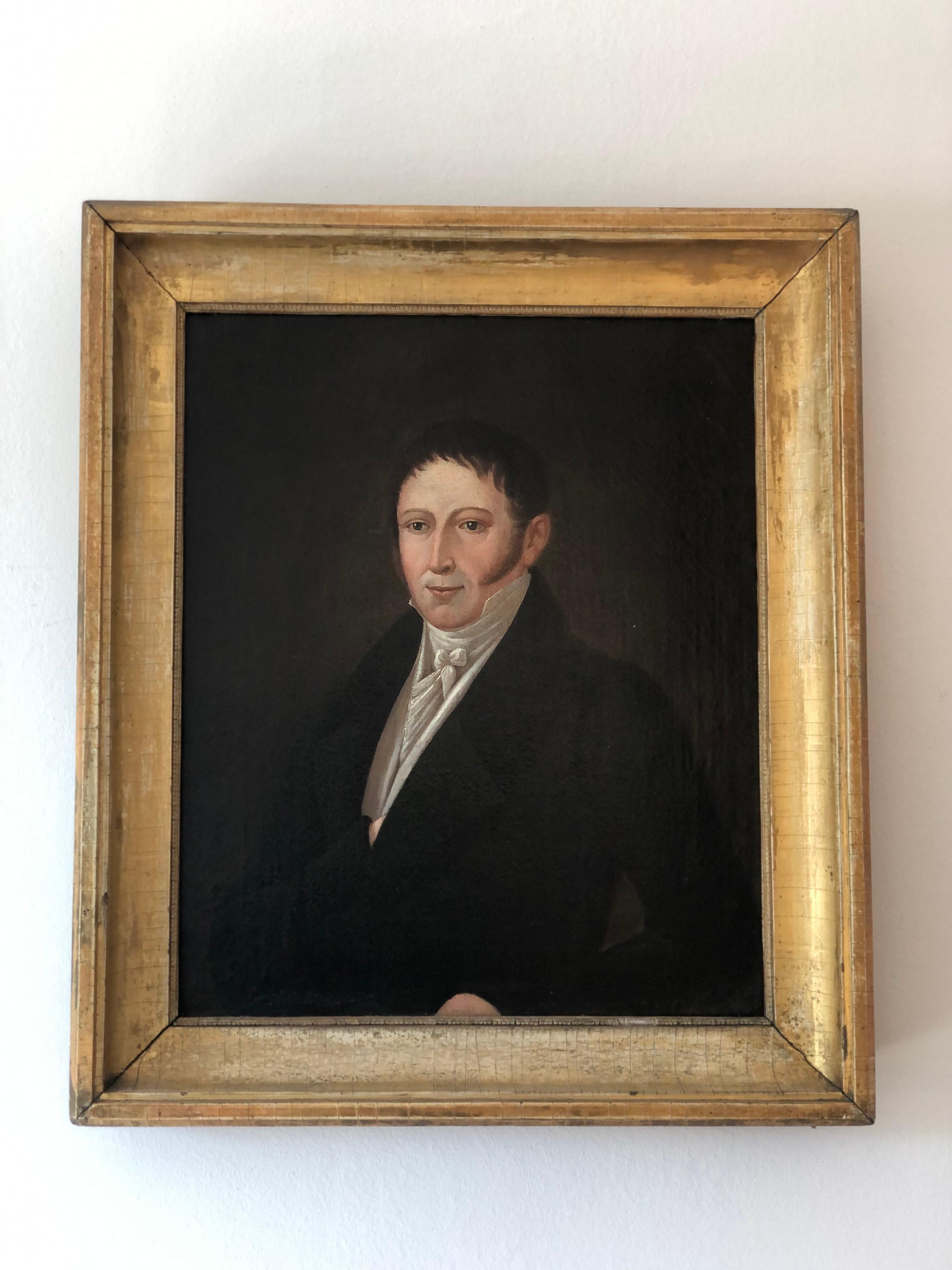 This early 19th century Biedermeier portrait painting features a German gentleman. He is wearing a dark green frock coat and white shirt with an upstanding collar and a white silk tie tied in a bow. His style reflects the refined style of the early