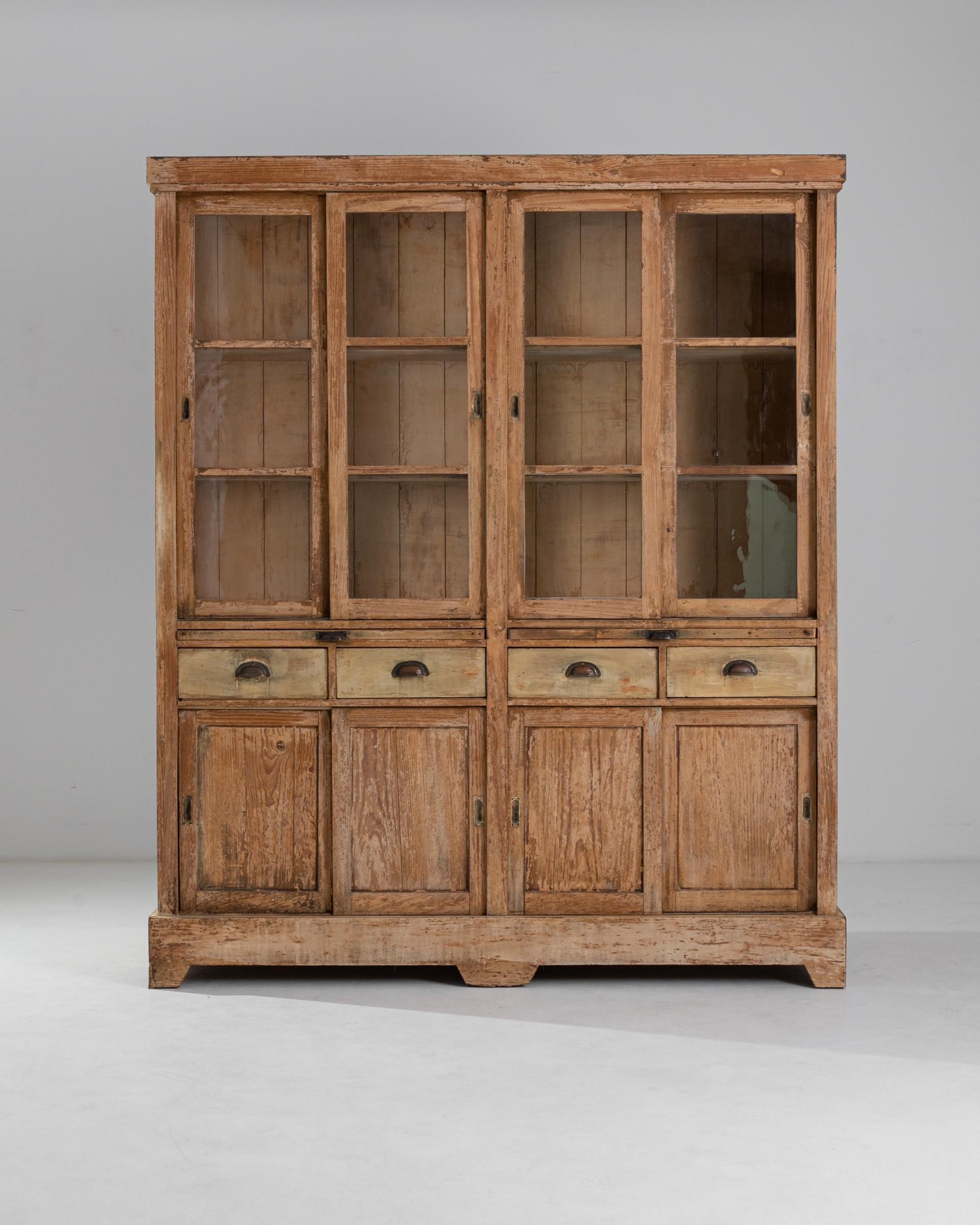 With its warm patina and handsome silhouette, this wooden vitrine offers an attractive antique showcase. Made in Portugal in the 1800s, the glass panes of the upper cabinet provide a window onto precious objects displayed on the shelves within.