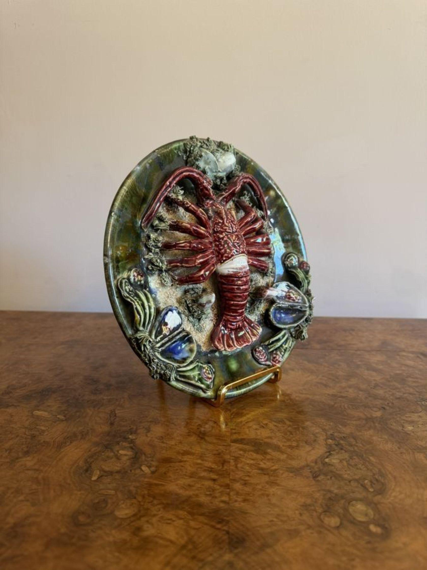 Antiguo plato de pared de langosta de mayólica portuguesa con una gran langosta sobre un plato verde con arena, algas y conchas marinas en un colorido esmalte. 

D. 1940