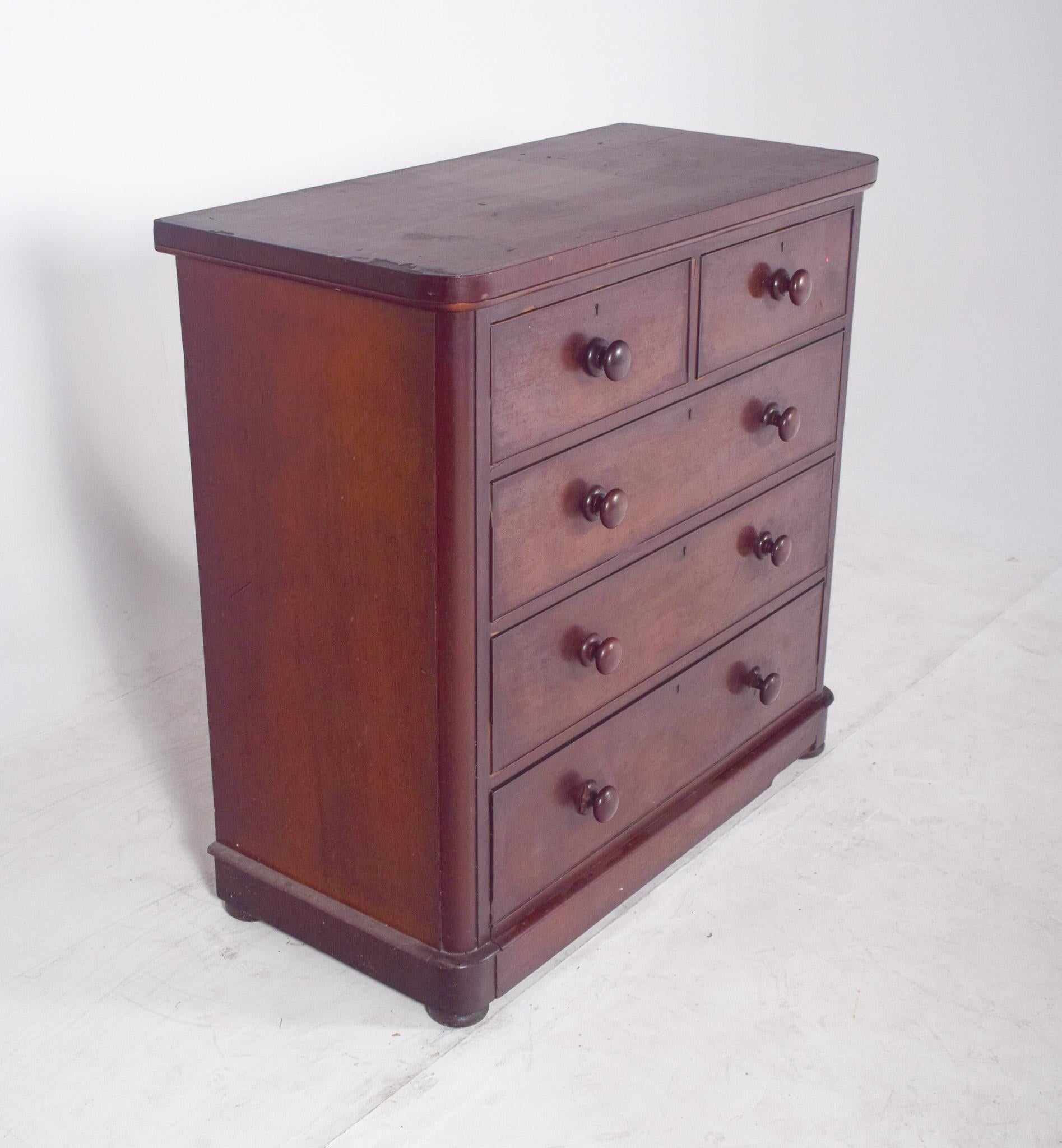 Romantic chest of drawers with wooden handles. Robust yet elegant in design, the chest of drawers has five drawers arranged in two small upper drawers and three large lower drawers, all with rounded handles in the same wood, which contributes to a