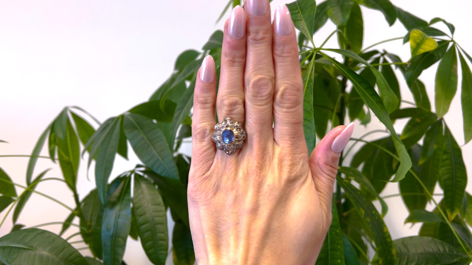 One Antique Portuguese Sapphire and Diamond Gold Silver Ring. Featuring one oval mixed cut sapphire weighing approximately 3.35 carats. Accompanied by 50 rose cut diamonds with a total weight of approximately 0.25 carat, graded faint to very light,