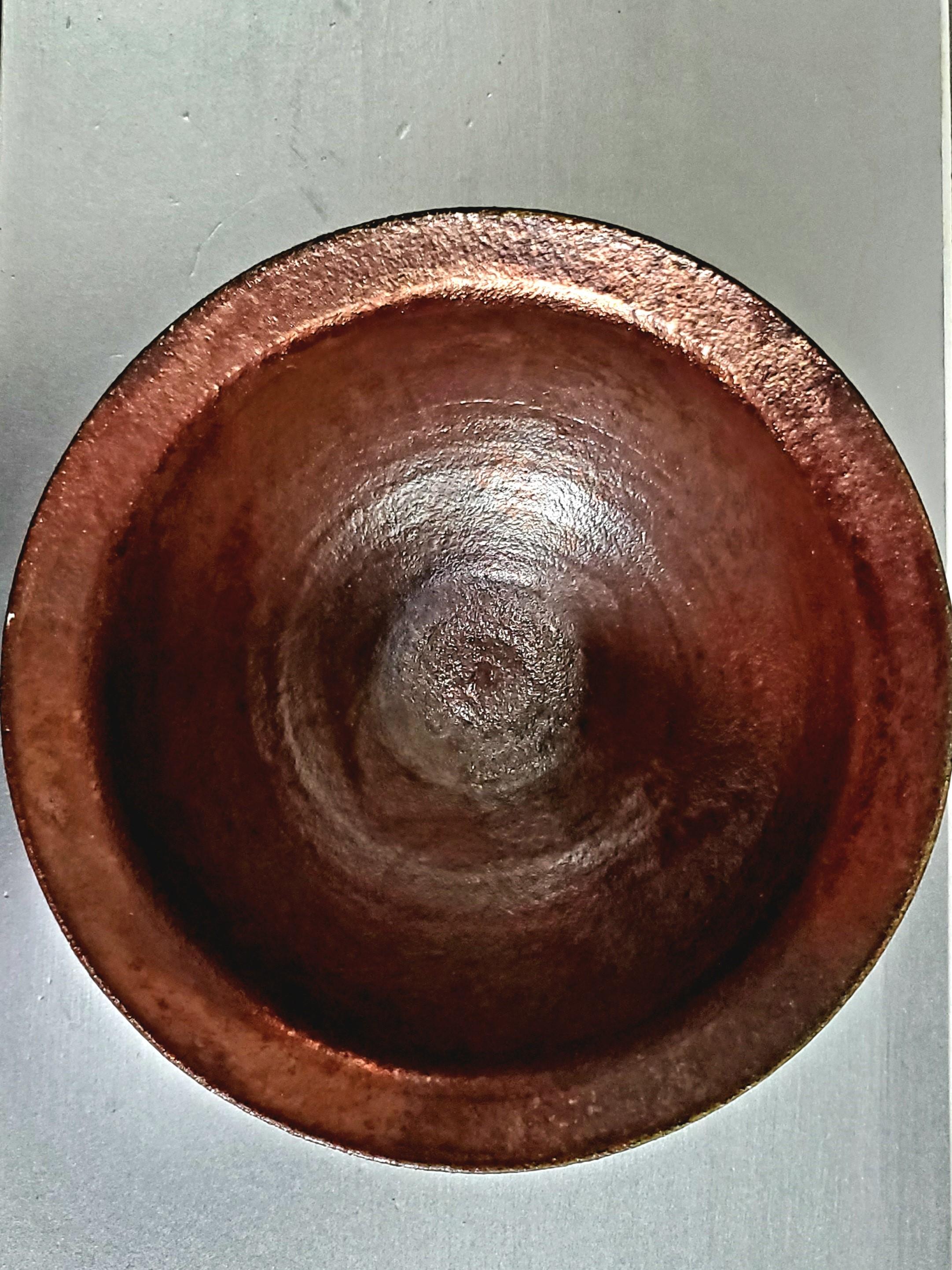 This stunning pottery bowl has an iridescent copper glaze with mimicked verdigris on a manganese–brown background. The glaze reflects the light, giving off a bright copper glow, and the iridescence and verdigris accents provide a delight to the