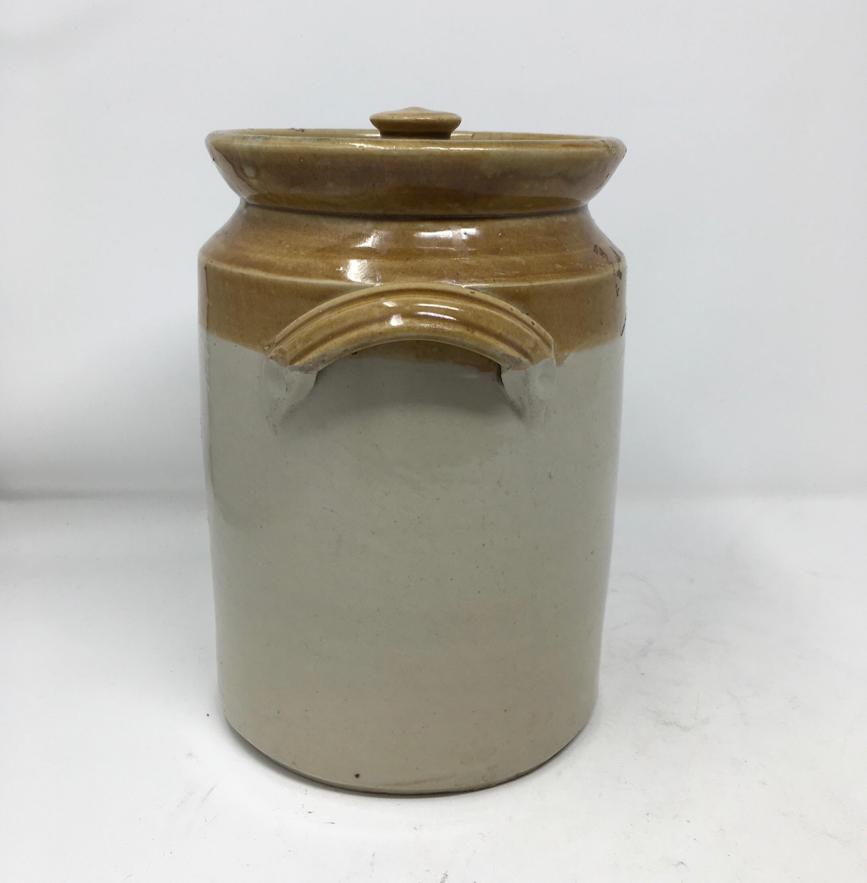 Imported from England, this 19th century sugar crock comes complete with its original lid. This two handled crock has a light cream color glaze on the bottom with a golden color on the top with 