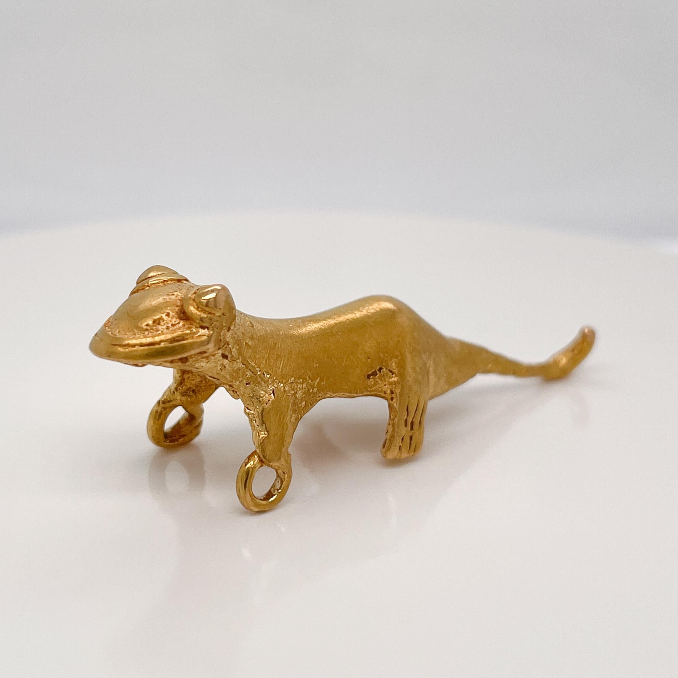 A very fine Pre-Columbian gold pendant.

In the form of a gecko or lizard with bulging eyes and a long tail.

With integral bails in each hand.

A wonderful figural Pre-Columbian pendant!

Provenance: From a private Connecticut collection. Purchased