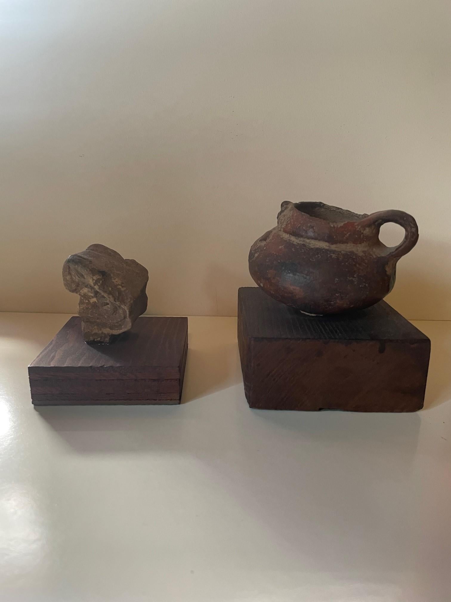 Magnifique ensemble de deux artefacts Pre-Columbian en forme d'oiseaux.

Une pierre à tête d'oiseau finement sculptée montée sur une base en bois primitif, en état ancien sans cassure majeure. Monté avec ce qui semble être une résine ou de l'époxy
