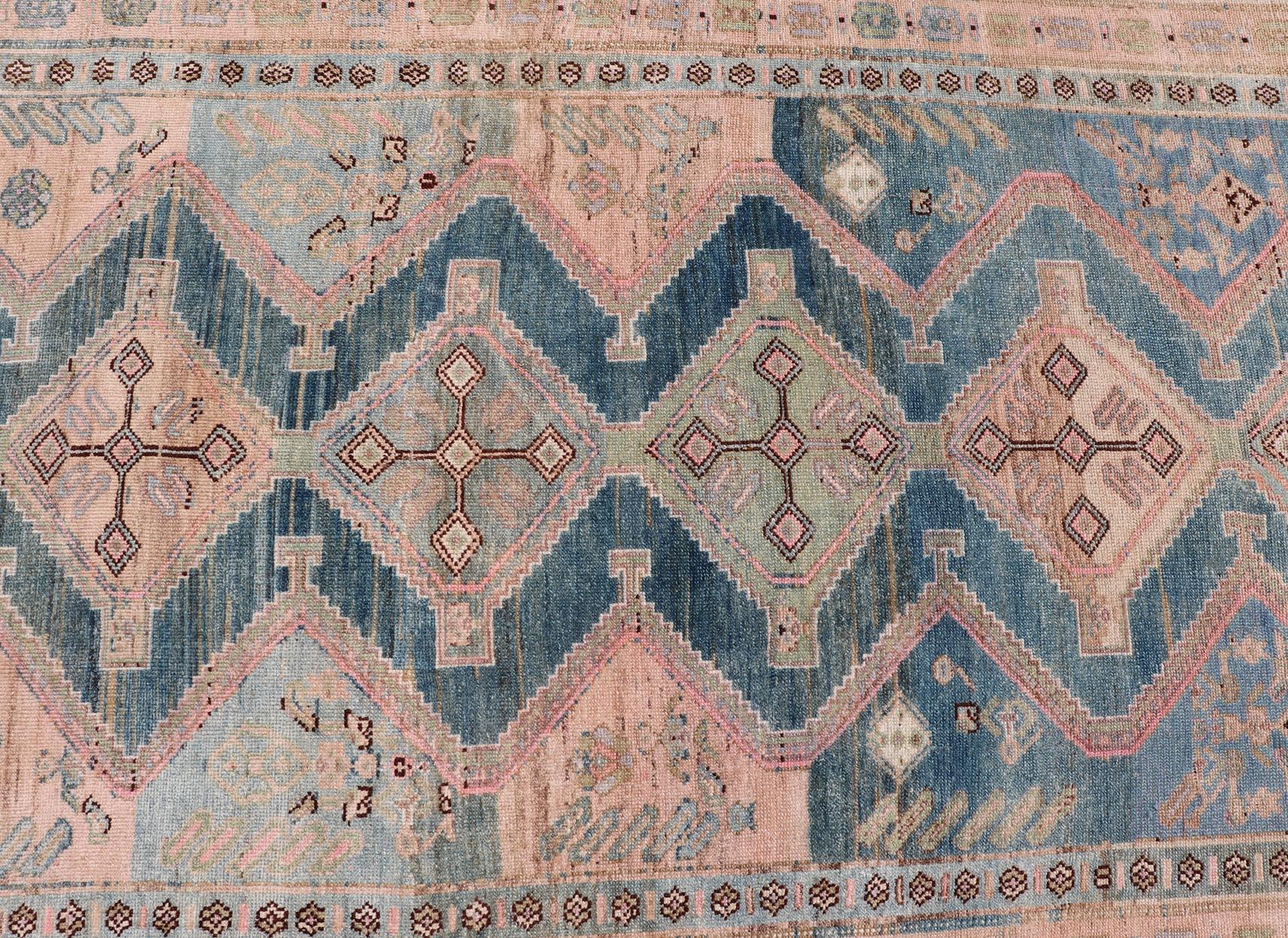 This antique Persian Kurdish rug has been hand-knotted in wool and features an all-over, Sub-geometric medallion design rendered in multicolor. A complementary, multi-tiered border encompasses the entirety of the piece; making it a marvelous fit for