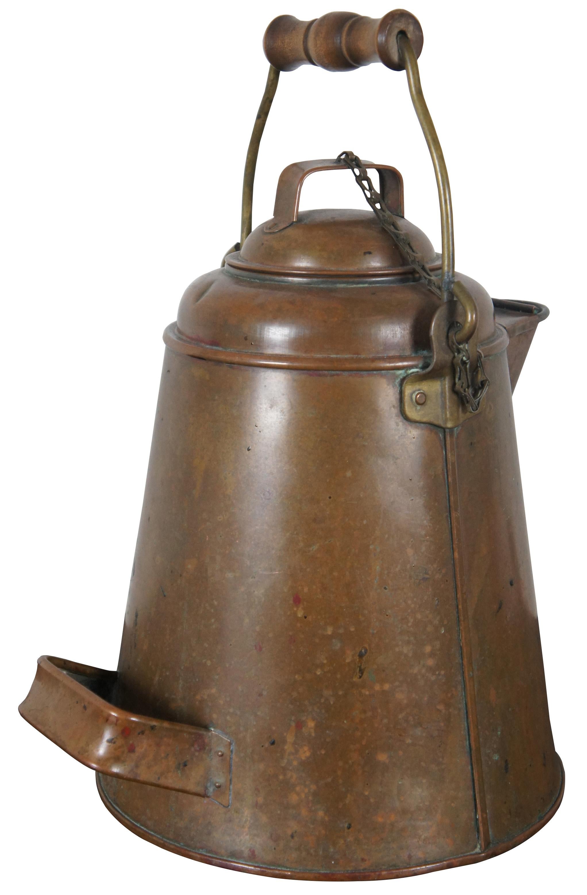 Large antique 19th century copper coffee pot or kettle. Made of copper over tin with wood handle and brass bale and attaching hardware. Used by cowboys and sailors in the late 19th century.

Measures: 12” x 10” x 13.5” / Height of handle – 6”