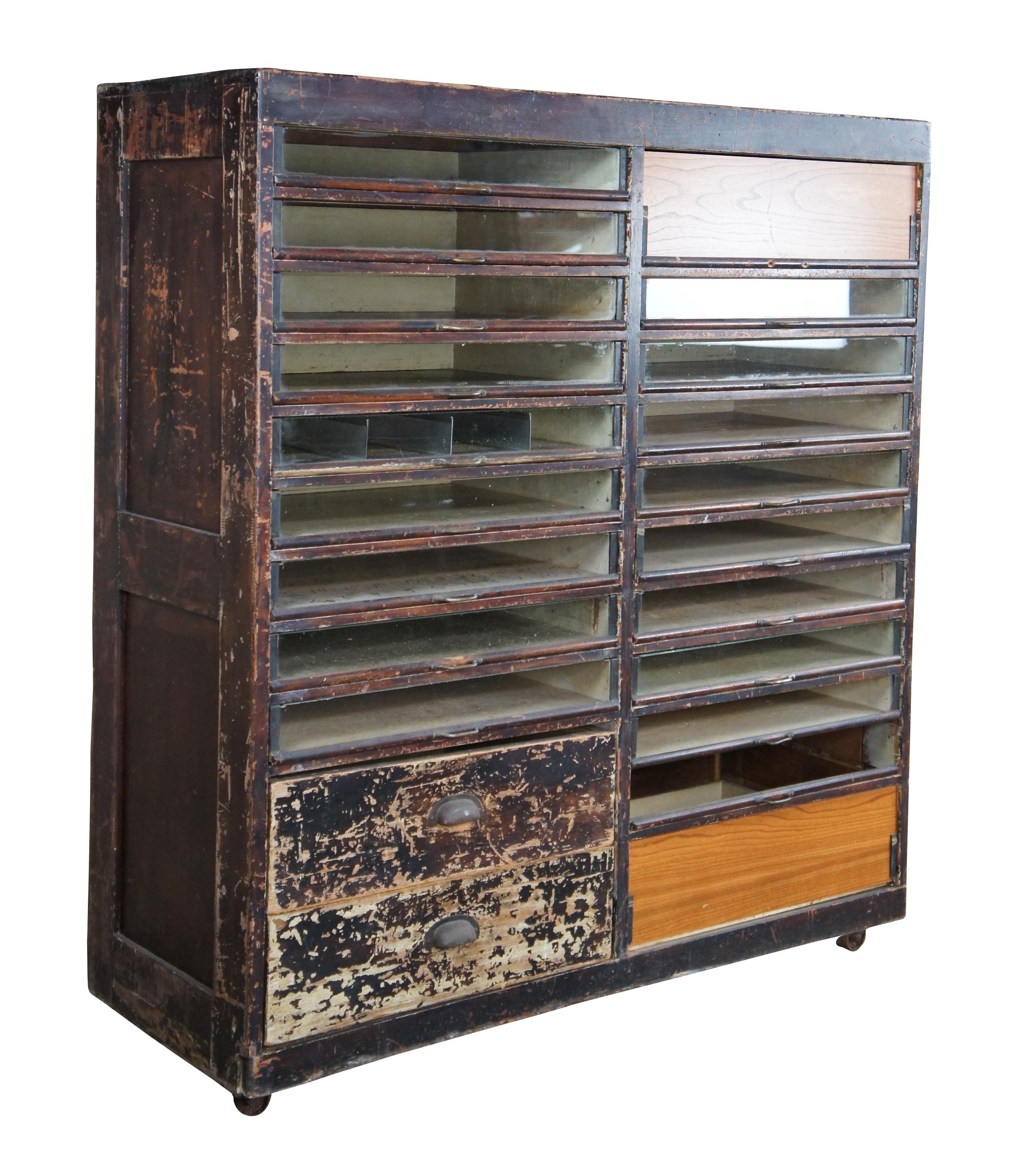 Antique apothecary cabinet, circa first half 20th century. Features a unique file system with clear plexi windows along the front. Includes 2 lower drawers along the left. Size: 50