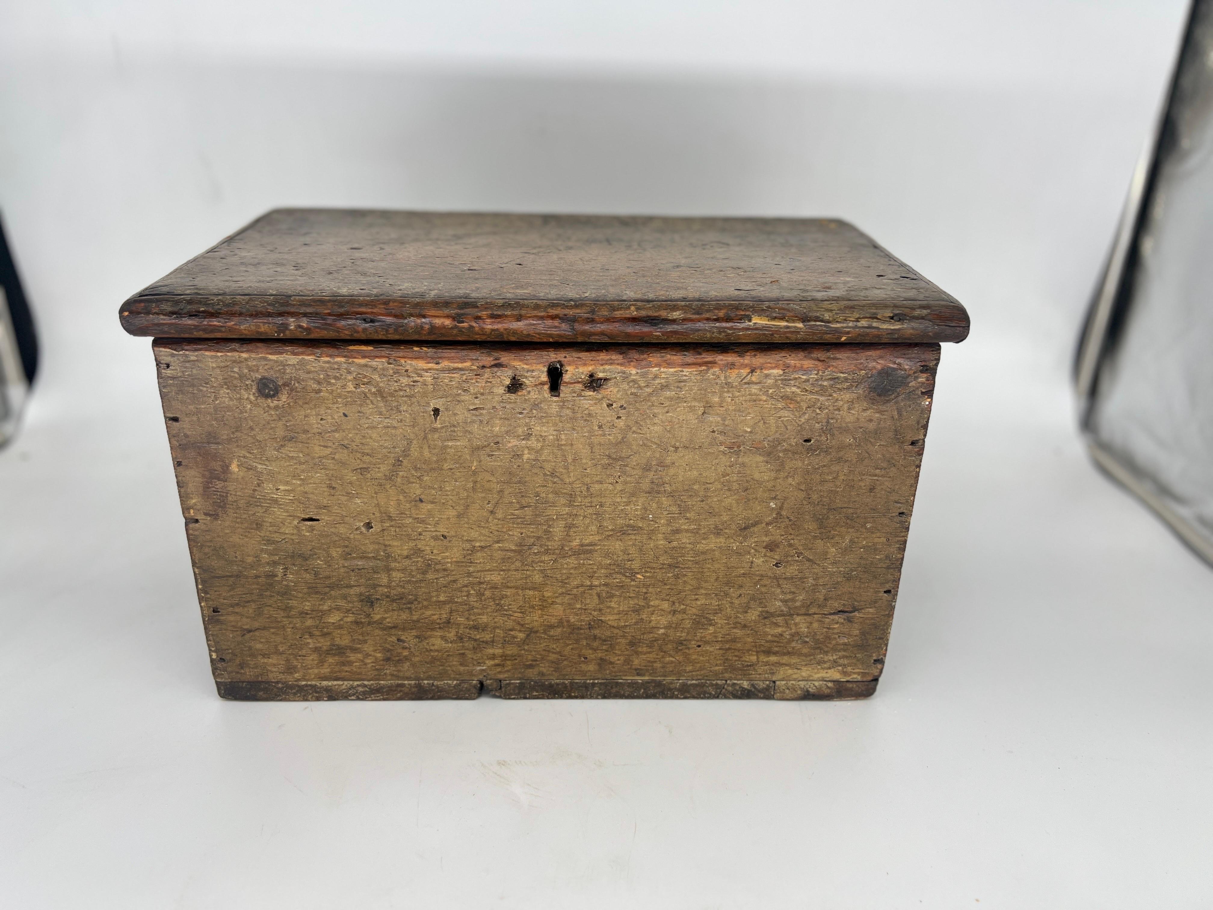 This antique American storage box exudes a charming rustic appeal with its hand-painted design on a sturdy wooden surface. The box dates back to the 1800s and features ample space to store tools or documents, making it perfect for collectors or