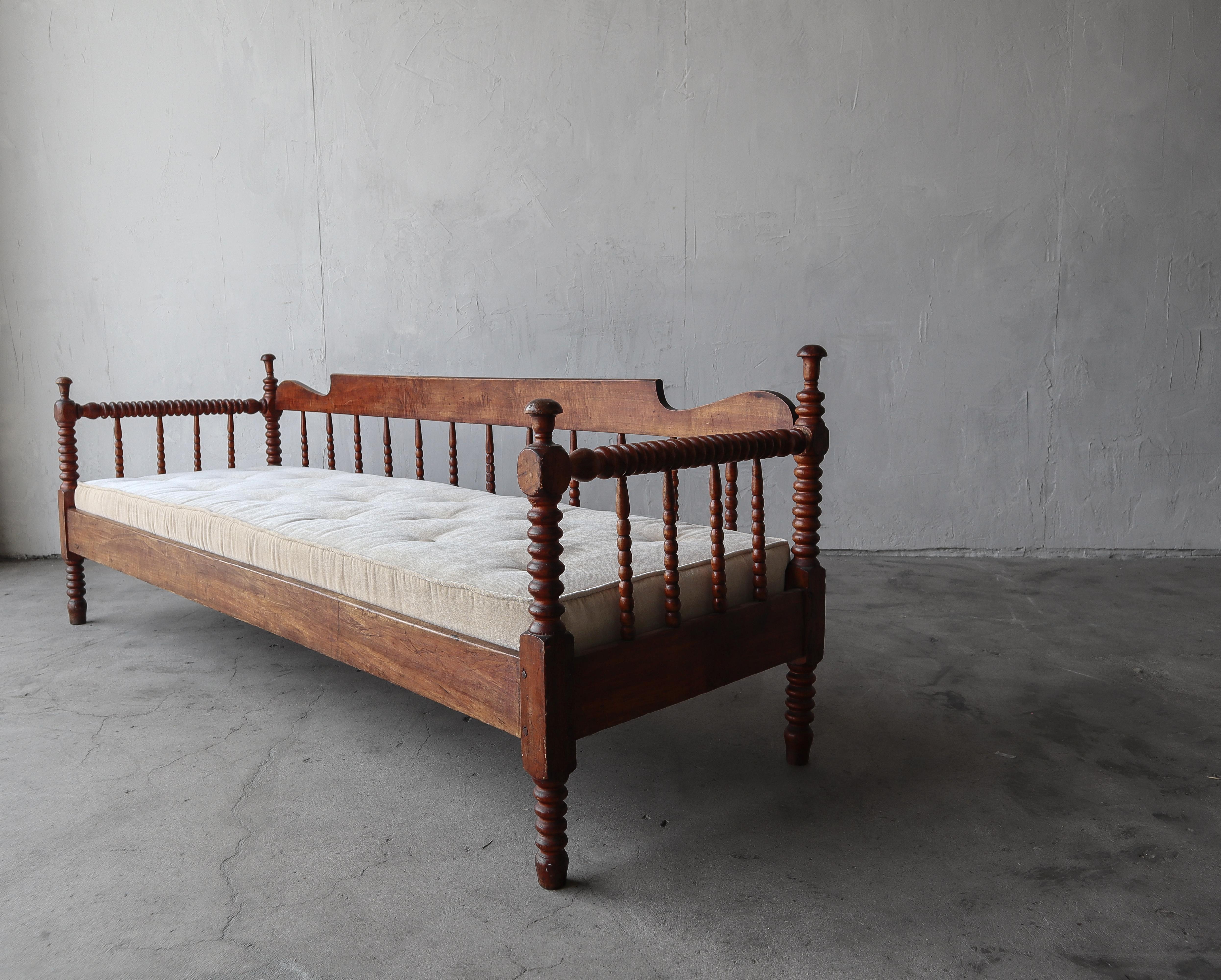Gorgeous primitive piece. Can be used as a daybed or bench. The beautiful patina of the wood against the fresh cream velvet upholstery really showcase this piece and all it's wonderful details.

The bench is structurally sound and 100% functional.
