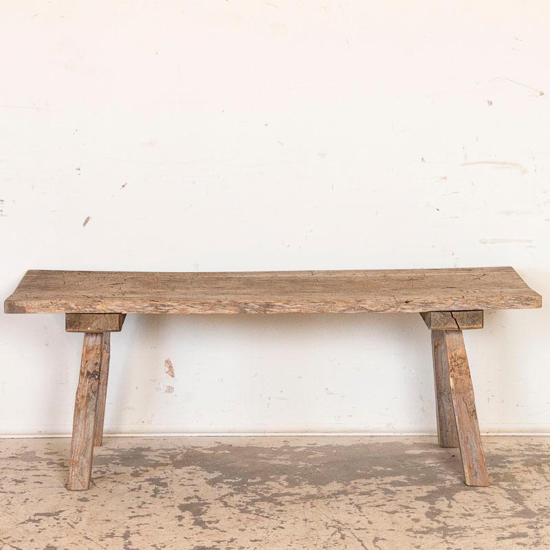 The weather wood of this rustic coffee table has been heavily distressed, indicating the 1.5