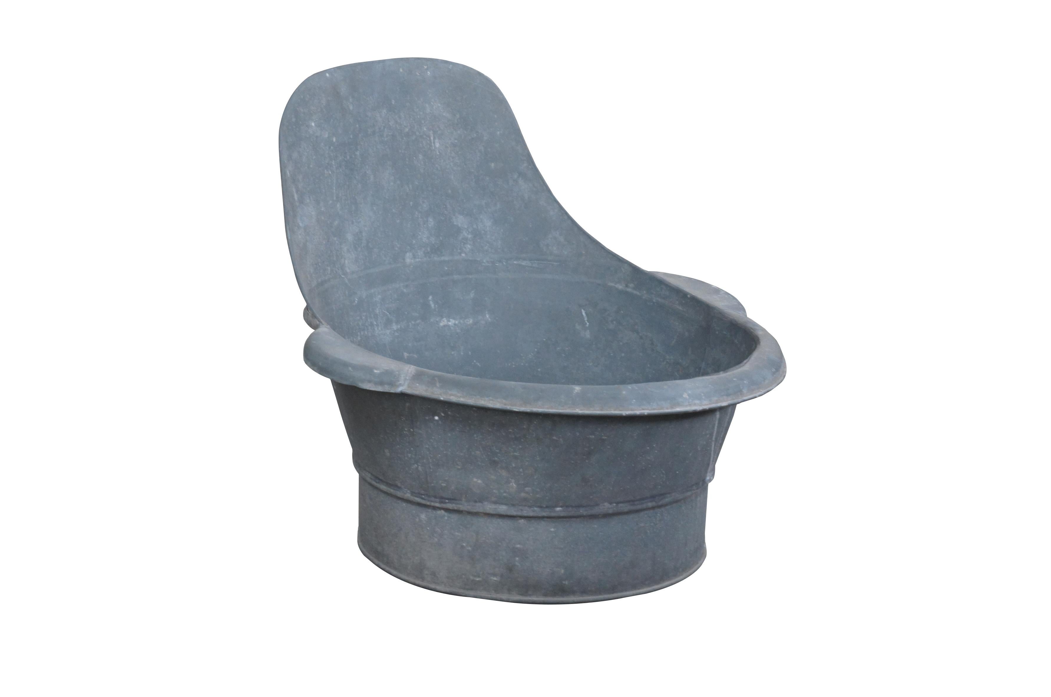 Primitive antique sit in bath or wash tub. Made of galvanized metal featuring back and arm rests. Measure: 27