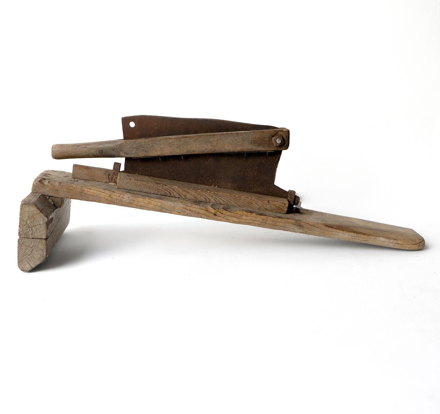 ANTIQUE JAPANESE STRAW CUTTER

A sculptural and decorative piece made from elm and steel.

A fixed blade is mounted in a wooden frame in which lengths of straw can be drawn and placed and a wooden handle is then lifted and brought down over the