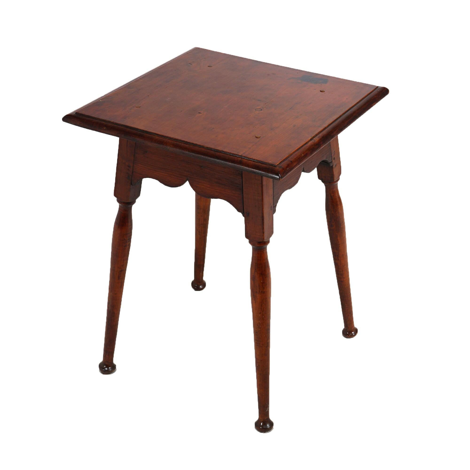 An antique primitive side table in the manner of those produced in early New England offers maple and pine construction with beveled square top over shaped skirt and raised on splayed turned legs, c1810

Measures- 27''H x 21''W x 21''D