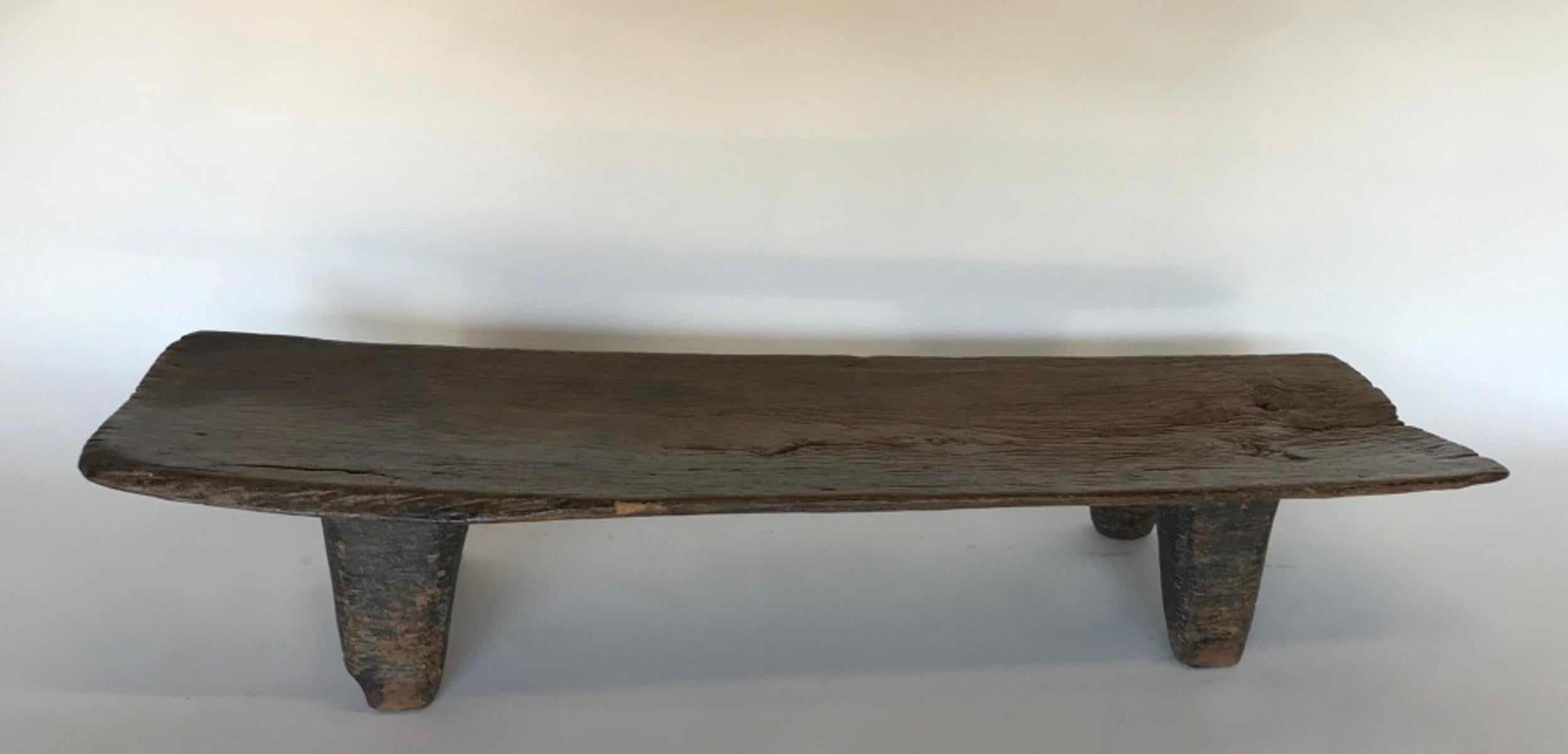 Carved from one piece of wood, this early 20th century child's bed can be used as a coffee table or bench. The wooden top has lovely graining and patina and is one solid piece. Wear is commensurate with the age of the piece. Beautiful patina. The
