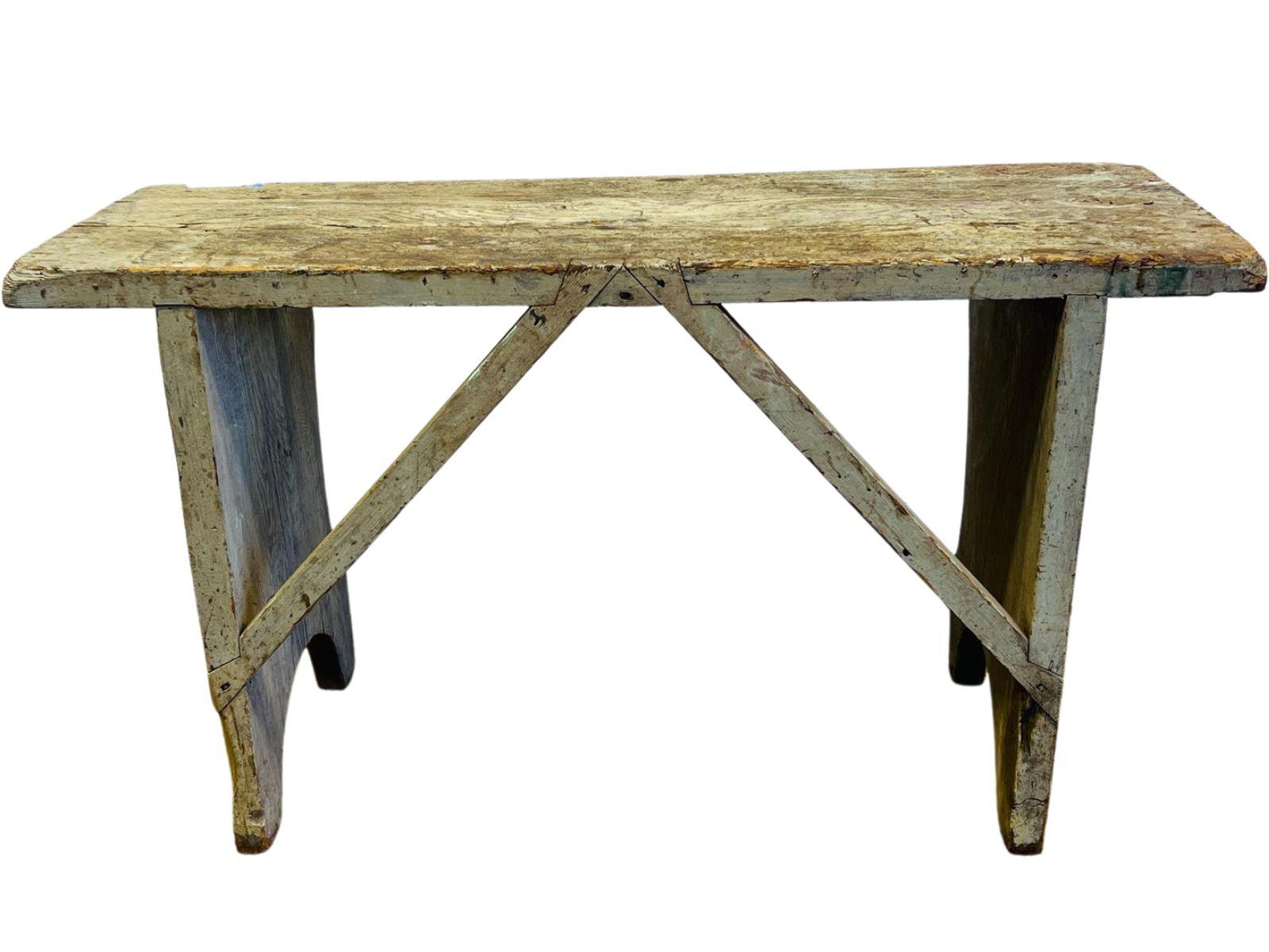 Un banc à seau primitif américain du XIXe siècle magnifiquement vieilli, construit à la main en bois de pin massif et conservant sa finition peinte authentique et usée par le temps. Cette pièce rustique et utilitaire a été conçue à l'origine pour