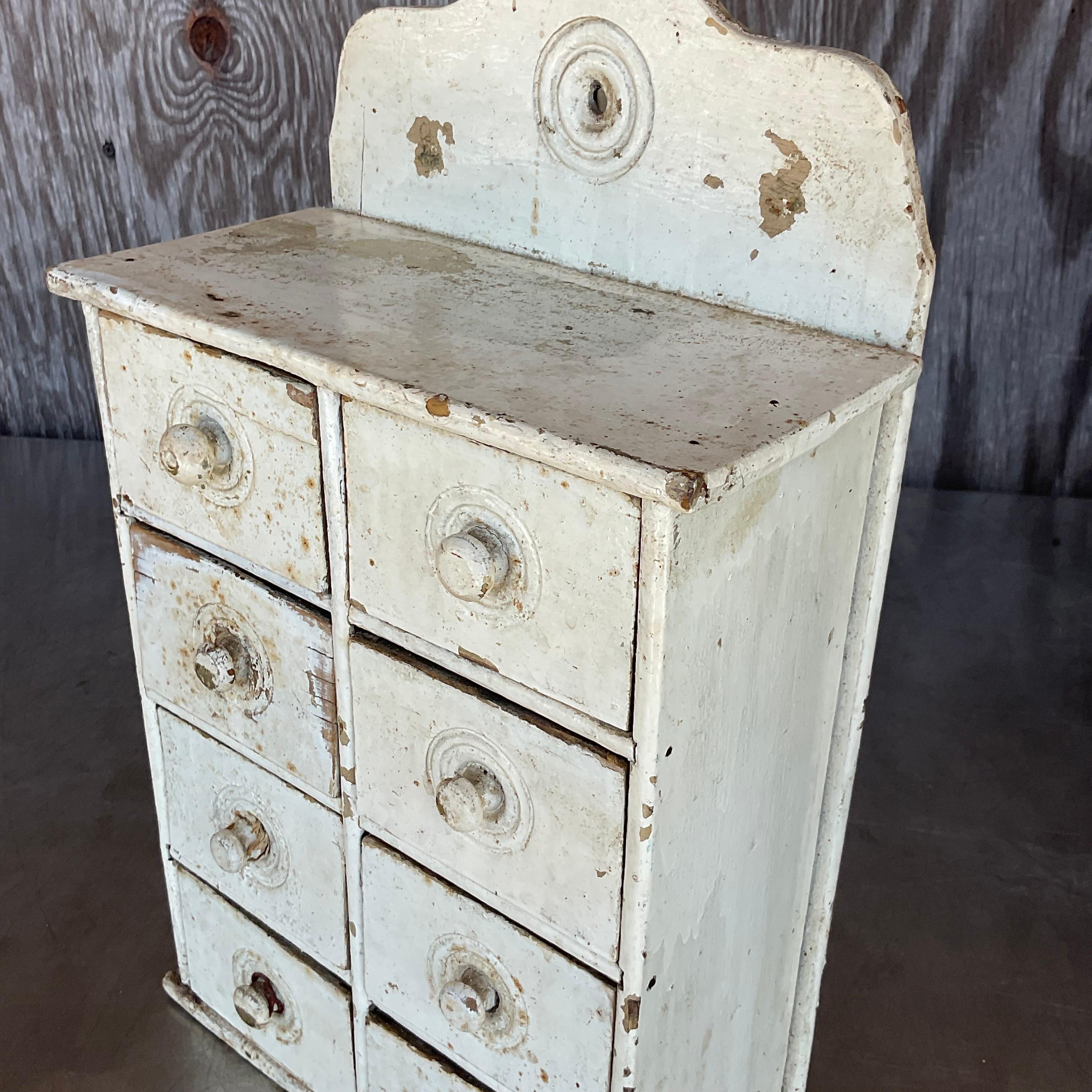 Crafted with rustic charm and aged character, this Antique Primitive Patinated Wall Cabinet embodies quintessential American style. Perfect for adding a touch of heritage to any space, its weathered patina tells a story of bygone eras and timeless