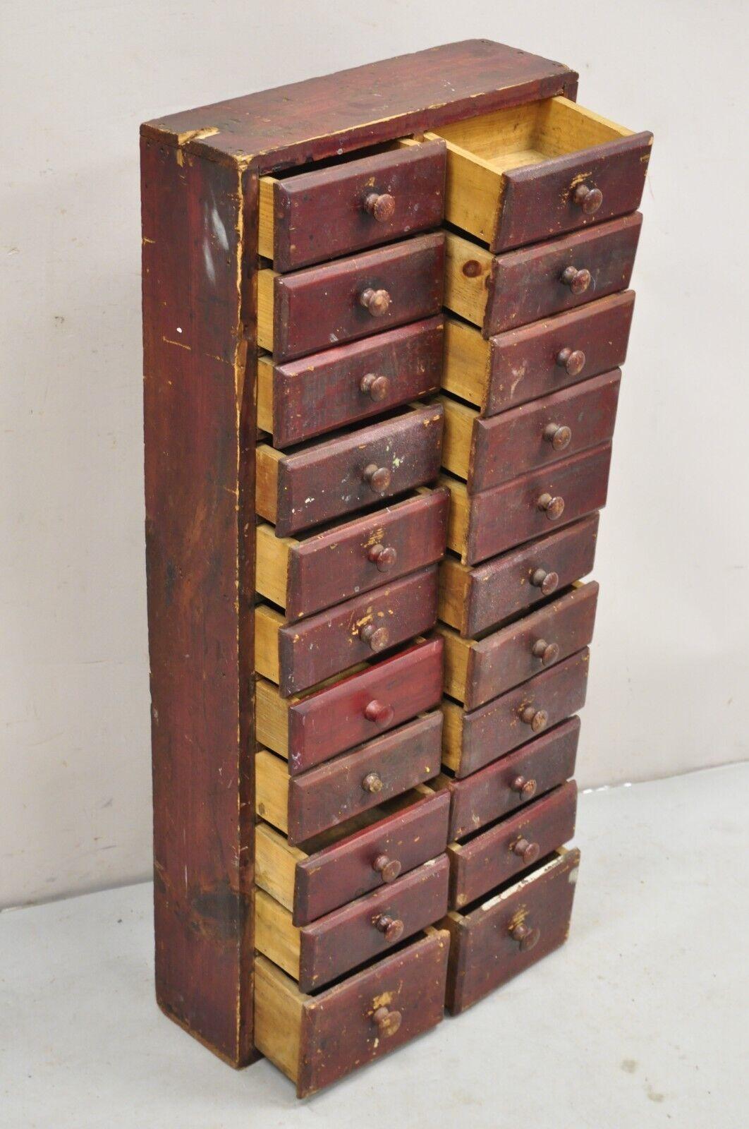 Antique Primitive Rustic Red Distress Painted Narrow Watchmakers Cabinet with 22 Drawer. Circa Early 20th Century. Measurements: 39