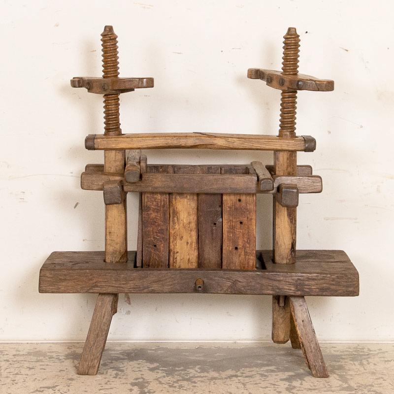 There is heft and substance to every part of this hand-built wine press, making it a fun and unusual find. Visually impressive are the hand-turned screws with carved handles and the old, wrought iron bolts and straps that support it. Every crack,